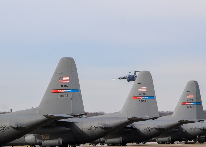 YOUNGSTOWN AIR RESERVE STATION, Ohio—A C-17 Globemaster III aircraft from the 446th Airlift Wing, Joint Base Lewis-McChord, Washington, approaches the flight strip beyond a line of 910th Airlift Wing C-130s here, Nov. 25, 2013. The C-17 arrived here to pick up 14 pallets of humanitarian cargo destined for Guatemala via the Denton Program, which provides military transportation for approved humanitarian assistance commodities destined for approved countries. Mission of Love, a charity based in Austintown, Ohio, collected the cargo. (U.S. Air Force photo/Eric White).