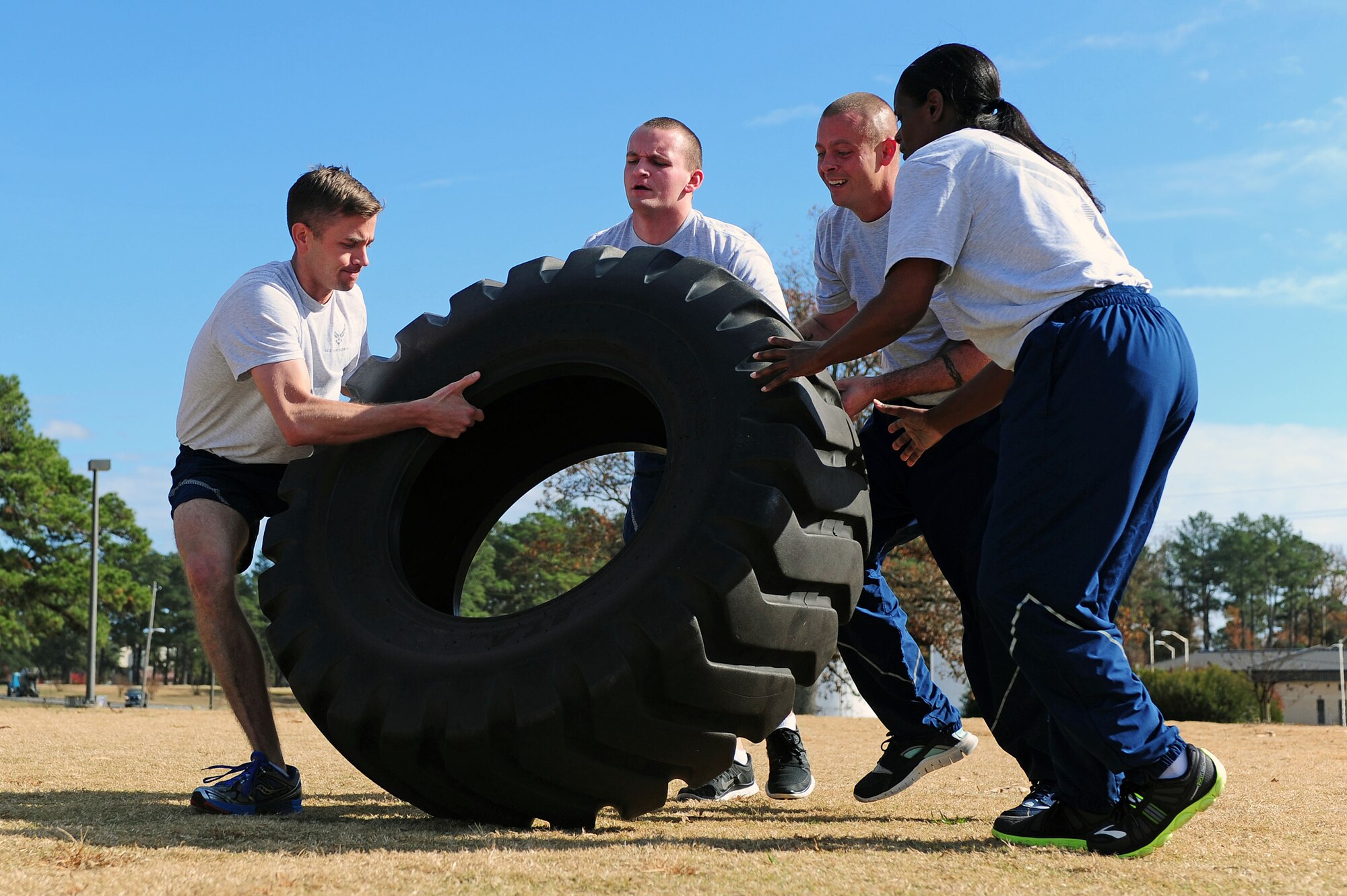 U.S. Air Force Airmen assigned to the 4th Fighter Wing work together to flip a tire during a commander’s challenge for a Comprehensive Airmen Fitness (CAF) Day event at Seymour Johnson Air Force Base, N.C., Nov. 22, 2013. In early 2010, Air Combat Command developed and implemented the CAF program to help Airmen, Air Force civilians and dependents become more resilient and better-equipped to deal with the rigors of military life. (U.S. Air Force photo by Airman 1st Class John Nieves Camacho/Not Released)