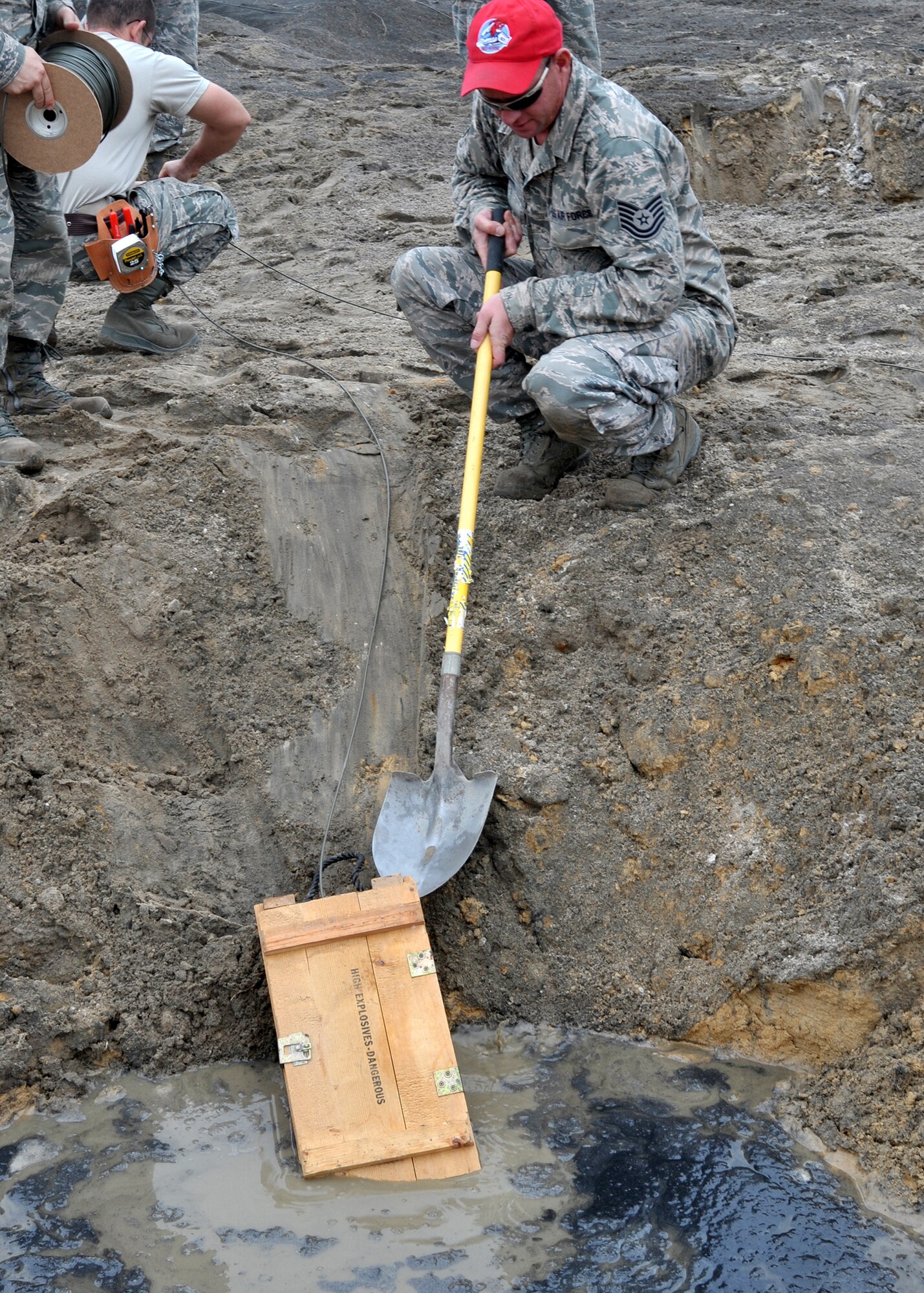 Tech. Sgt. Joseph Dwan, 823rd RED HORSE Squadron heavy equipment and construction supervisor, pushes a crate of TNT into a large crater during demolition qualification training at Hurlburt Field, Fla., Nov. 21, 2013. Airmen practiced with various explosives including C4, TNT, military-grade dynamite, 40-pound shape charges, and 40-pound cratering charges during their training. (U.S. Air Force photo/Senior Airman Kentavist P. Brackin)
