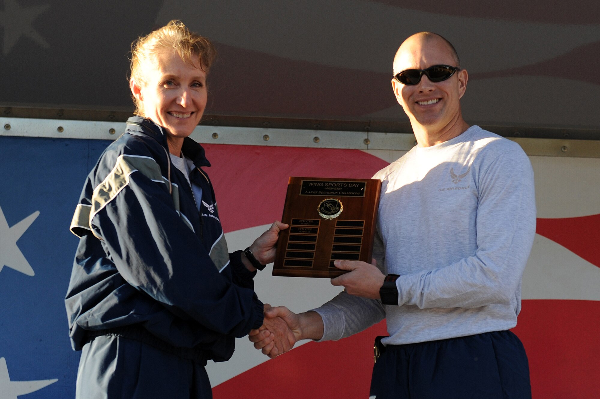 U.S. Air Force Lt. Col. Dave Pike, 911th Air Refueling Squadron commander, receives the large-squadron championship award from Col. Jeannie Leavitt, 4th Fighter Wing commander, for the squadron’s overall success in the wing’s Comprehensive Airman Fitness (CAF) D ay at Seymour Johnson Air Force Base, N.C., Nov. 22, 2013. Once a quarter, the 4th FW holds a CAF day to focus on building physical, mental, social and spiritual strengths to improve resiliency. (U.S. Air Force photo by Airman 1st Class Aaron J. Jenne)