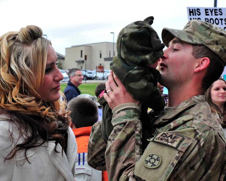 U.S. Army Reserve Spc. Robert Martin, 946th Transportation Company motor transport operator, holds his newborn son, Blake,  for the first time as his wife, Jessica Martin, looks on after returning home from his deployment Nov. 23, 2013, at Dover Air Force Base, Del. Martin was deployed to Afghanistan when his son was born. (U.S. Air Force photo/Airman 1st Class William Johnson)