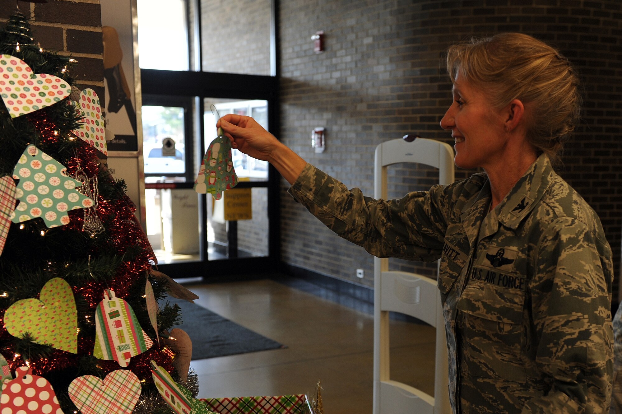 U.S. Air Force Col. Jeannie Leavitt, 4th Fighter Wing commander, picks the first ornament from the Angel Tree at Seymour Johnson Air Force Base, N.C., Nov. 21, 2013. Each ornament has the name and wish list of a child whose family may not be able to provide gifts during the holidays. (U.S. Air Force photo by Airman 1st Class Aaron J. Jenne)