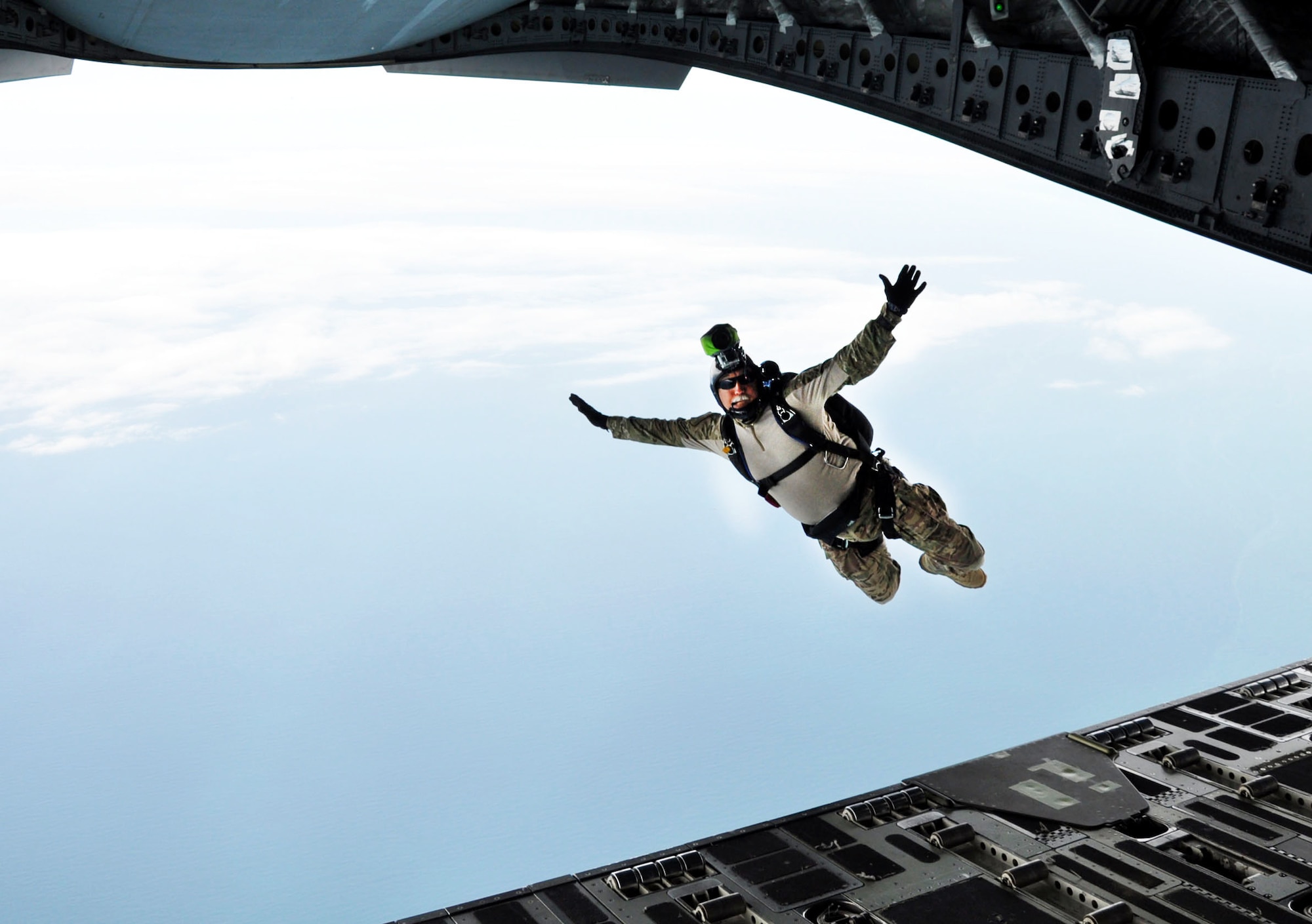OHAKEA, New Zealand -- Chief Master Sgt. Paul Koester, 517th Expeditionary Airlift Squadron jumpmaster, freefalls from the C-17 Globemaster III ramp into a high-altitude low-opening parachute deployment during Exercise Kiwi Flag over the New Zealand Defence Force Raumai Drop Zone near Ohakea, New Zealand. Kiwi Flag is a multilateral Royal New Zealand Air Force-sponsored tactical airlift exercise at RNZAF Base Ohakea. (U.S. Air Force photo by Senior Master Sgt. Denise Johnson/Released)