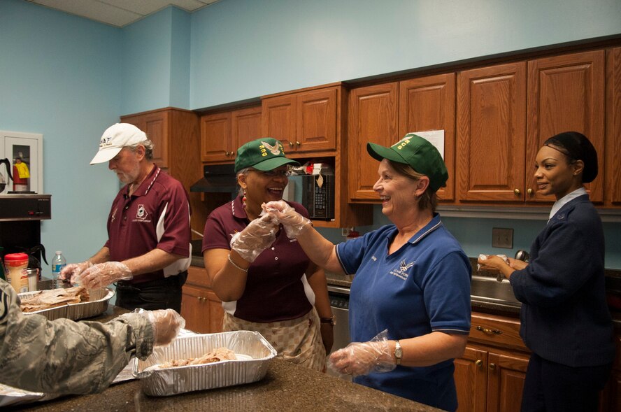 Retired U.S. Air Force Chief Master Sgt. Leila Brown, 336th Recruiting Squadron recruiter support manager, left, and Dot Clisby, 336th RCS operations administrator, break a wishbone during the Thanksgiving Luncheon at Moody Air Force Base, Ga., Nov. 21, 2013. Members of the 336th RCS volunteered to work in the kitchen. (U.S. Air Force photo by Airman 1st Class Sandra Marrero/released)
