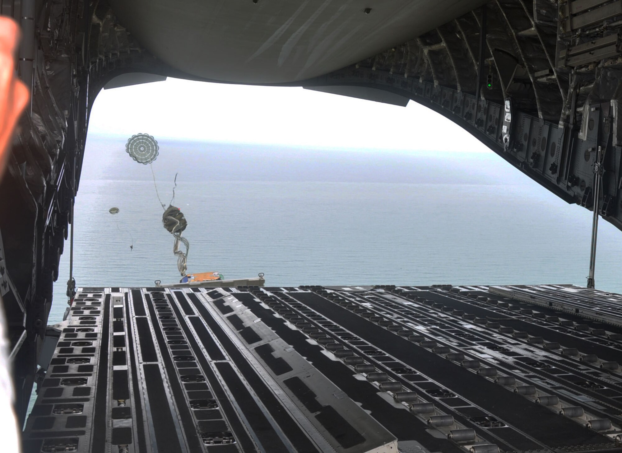 OHAKEA, New Zealand -- The tip of the cargo pallet is just visible over the edge of the C-17 Globemaster III cargo ramp before it begins its 1,000-foot descent during the multilateral RNZAF-sponsored tactical airlift exercise, Kiwi Flag, at Royal New Zealand Air Force Base Ohakea, New Zealand. The force of the extraction parachute unfurls the main parachute from its pack atop the pallet. Kiwi Flag personnel are supporting Exercise Southern Katipo -- held in New Zealand’s South Island -- by managing air operations and providing cargo and passenger airlift including tactical air drops to SK participants. (U.S. Air Force photo by Senior Master Sgt. Denise Johnson/Released)