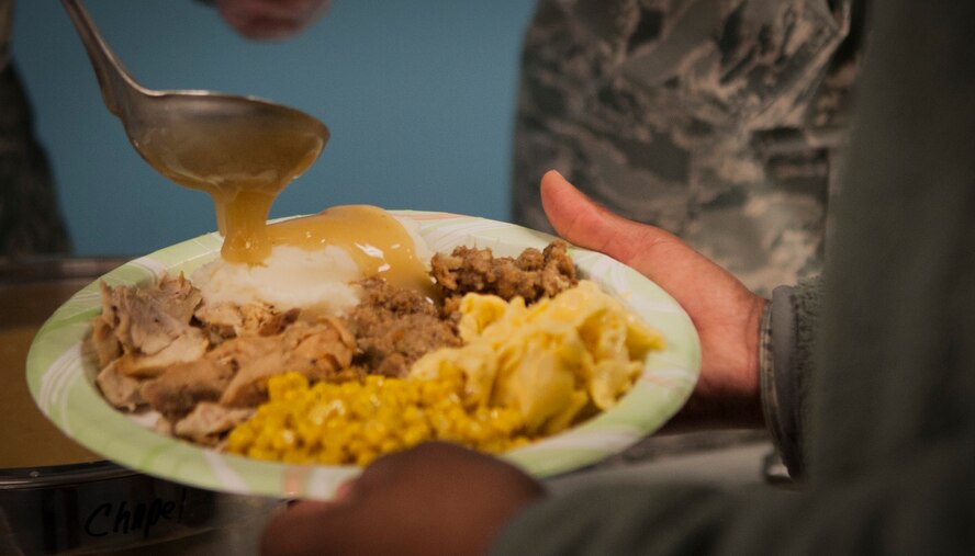 A member of base leadership helps serve a meal during the Thanksgiving Luncheon at Moody Air Force Base, Ga., Nov. 21, 2013. The luncheon was for Airmen E-4 and below who might not spend the holiday with their families. (U.S. Air Force photo by Airman 1st Class Sandra Marrero/released)
