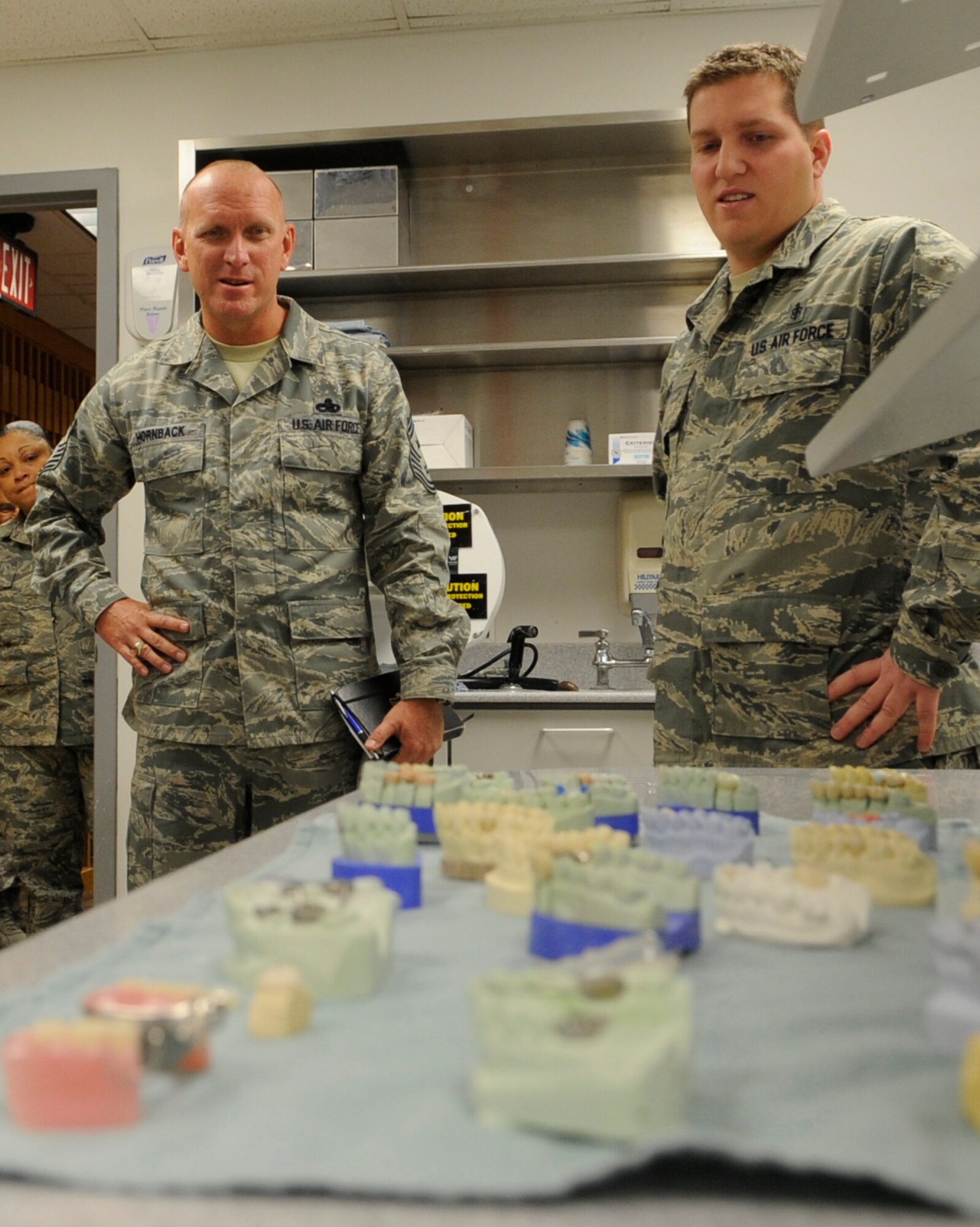 Staff Sgt. Casey Price, 509th Medical Operation Squadron dental technician, explains his work to Chief Master Sgt. Brian Hornback, Air Force Global Strike Command command chief, during his visit to Whiteman Air Force Base, Mo., Nov. 13, 2013. Hornback said what he will remember the most about Airmen at Whiteman is their professionalism. (U.S. Air Force photo by Staff Sgt. Alexandra M. Boutte/Released)