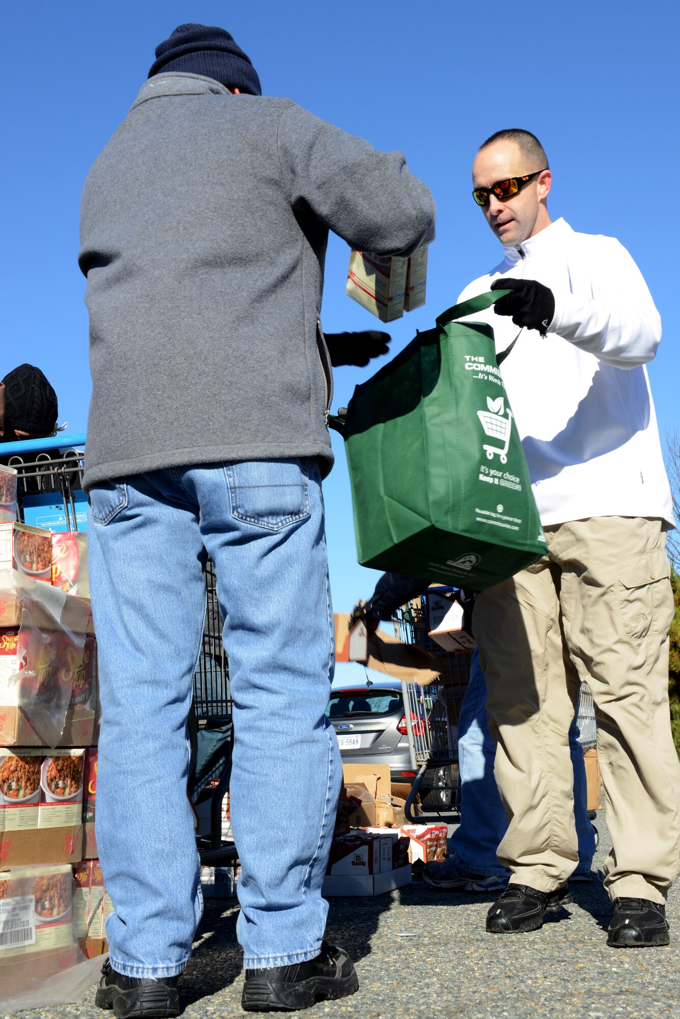 U.S. Air Force Master Sgt. Robert Mediavilla, 633rd Medical Group first sergeant, gathers food donations in a “basket” as part of an Operation Warmheart holiday food drive at Langley Air Force Base, Va., Nov. 24, 2013. Operation Warmheart is a year-round charity program led by the Langley First Sergeants Council to assist Airmen in need. (U.S. Air Force photo by Airman 1st Class Kimberly Nagle/Released) 