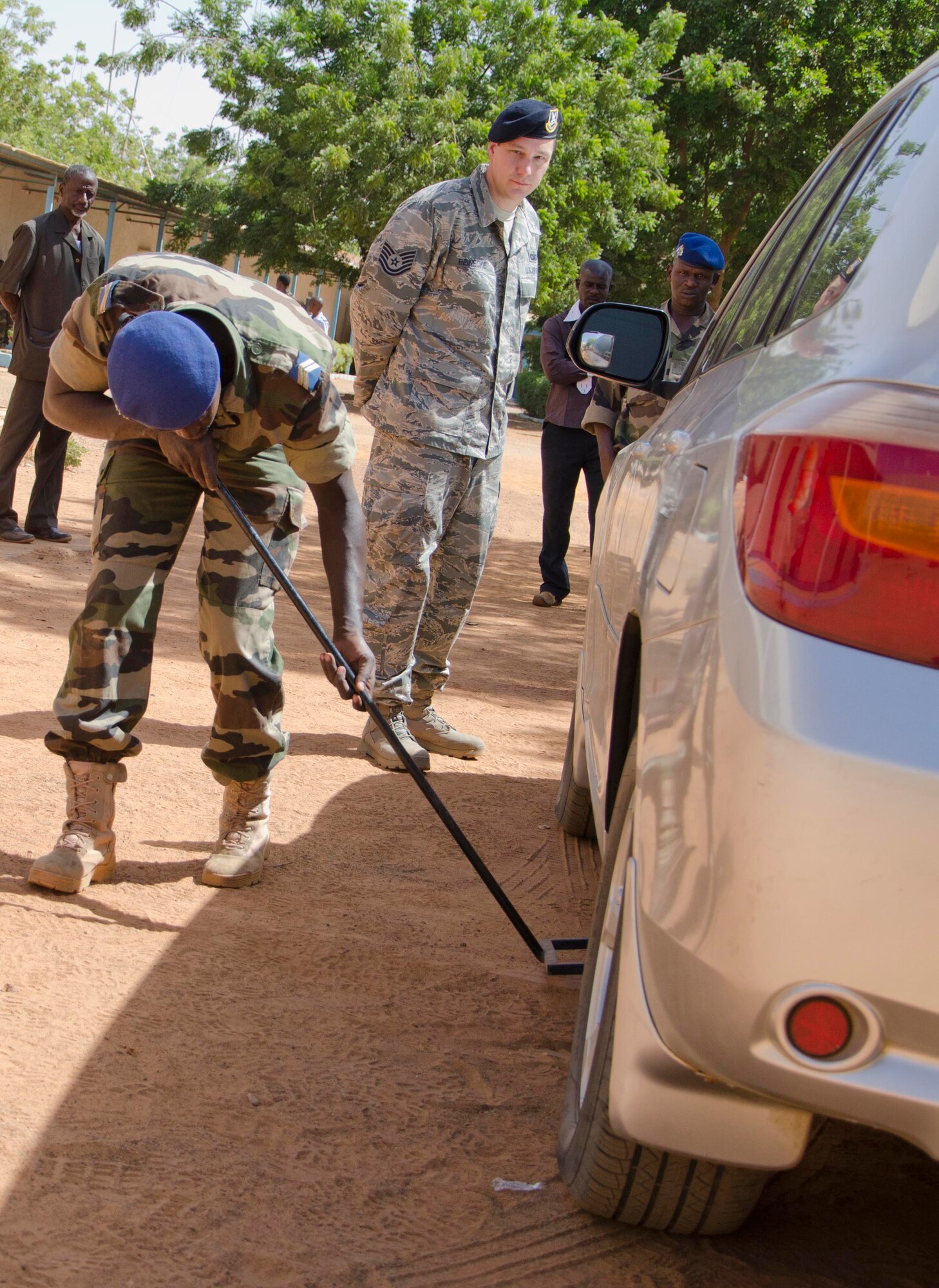 NIAMEY, Republic of Niger -- Tech. Sgt. Mark Reinecke, 818th Mobility Support Advisory Squadron air advisor, conducts vehicle search training with Sgt. Hamadou Amadou, Niger National Flight at Airbase 101, Niamey, Niger, Nov. 6, 2013. The 818 MSAS sent a seven Airmen logistics management assistance team to provide a complete air mobility/logistics expertise package that was tailored to fit the needs of its partner nation. The program helps develop the partner nation's ability to conduct air mobility operations through technical courses and achieve self sufficiency. (U.S. Air Force photo by Maj. Sean Hook)
