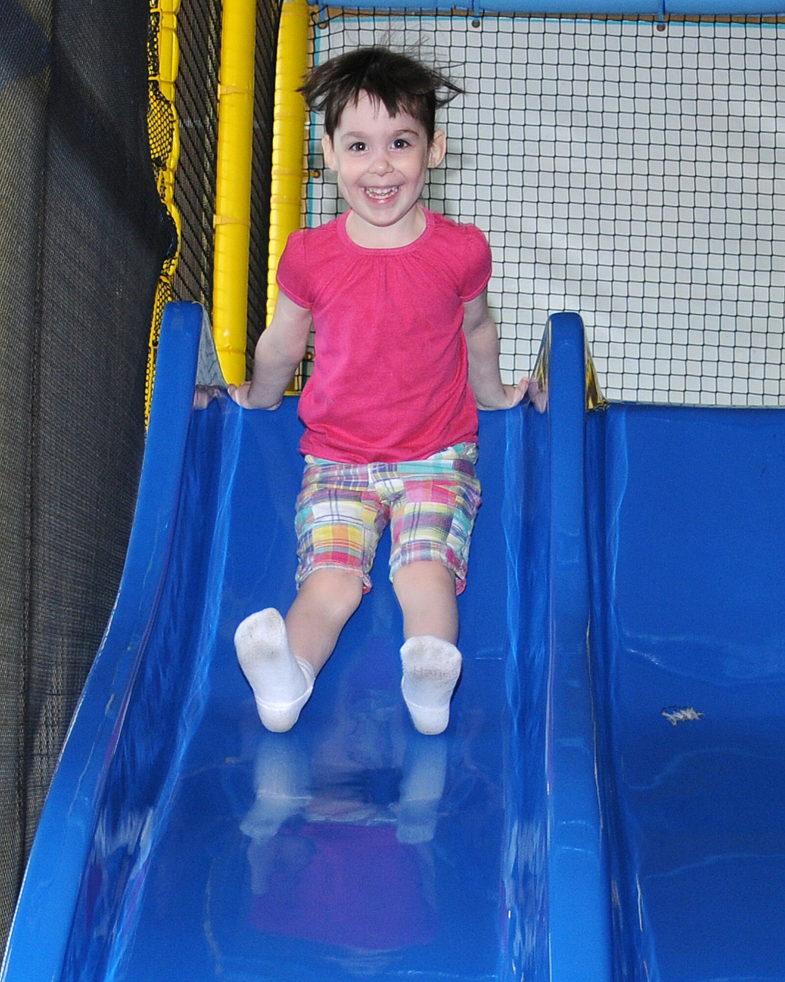 Jemma Byrd, 4, daughter of Staff Sgt. Jason Byrd, 352nd Special Operations Support Squadron transmission systems supervisor from Houston, Texas, uses the slide June 26, 2013, in the Fun Zone at the Bob Hope Community Center on RAF Mildenhall, England. The BHCC is open on Thanksgiving day from noon to 7 p.m., and 9 a.m. to 9 p.m. on the Family Day (Nov. 29, 2013). Children must be supervised at all times and remove shoes before using the equipment. (U.S. Air Force photo by Gina Randall/Released)