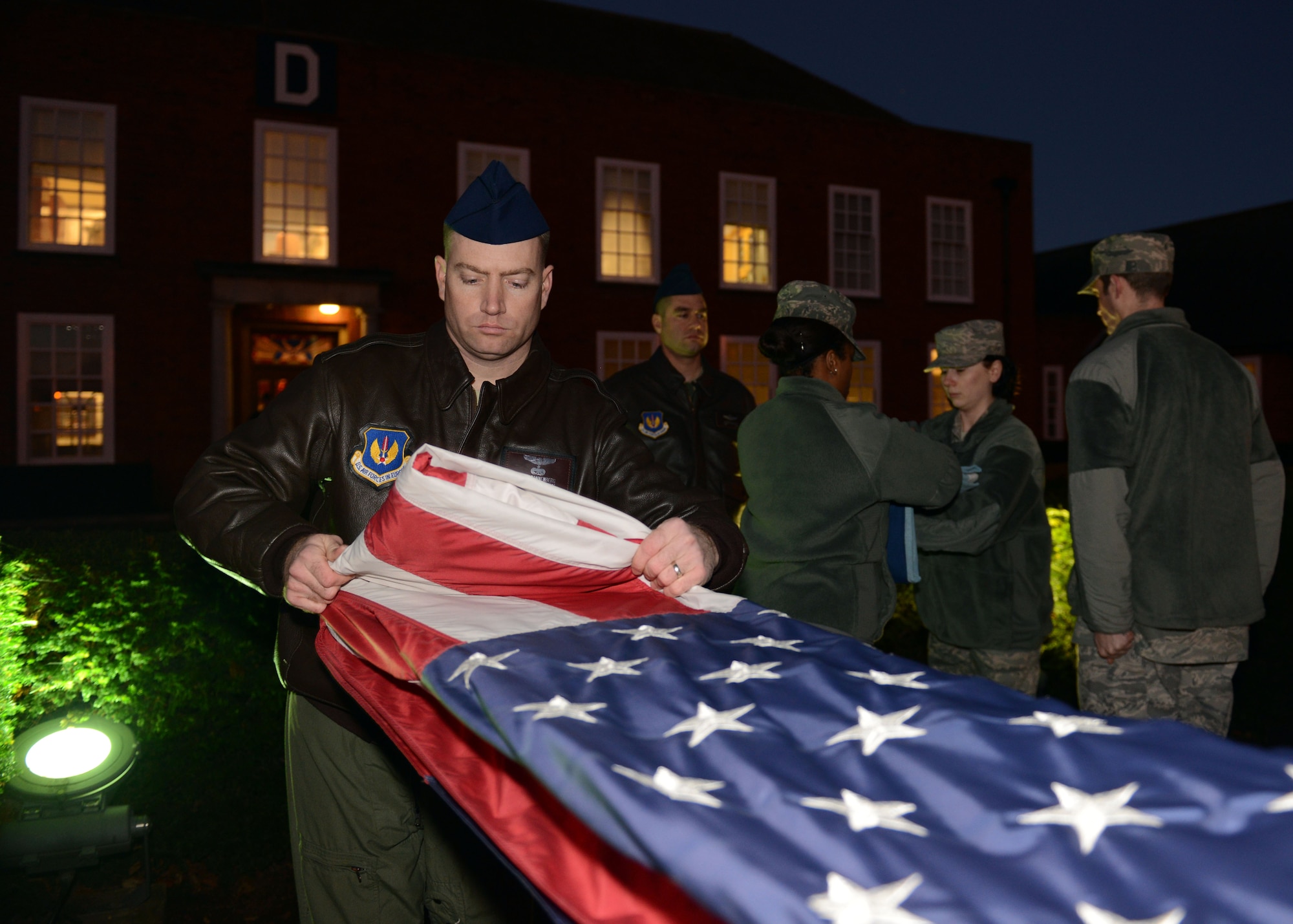 Members of a Team Mildenhall flag detail fold the U.S. flag and Royal Air Force ensign during a retreat ceremony Nov. 22, 2013, on RAF Mildenhall, England. A retreat ceremony, in which the U.S. flag and RAF ensign are retired, takes place the last Friday of every month. A team of Airmen secured both the U.S. flag and the RAF ensign as part of the ceremony, which honors the colors and signals the official end of the duty day. (U.S. Air Force photo by Airman 1st Class Preston Webb/Released)