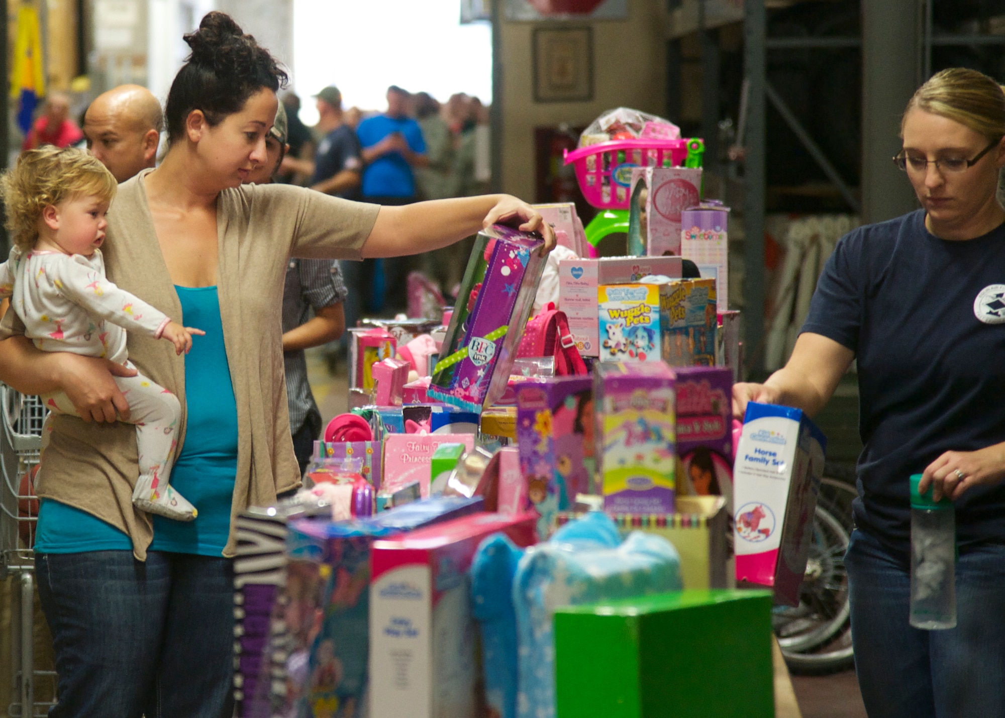 Kaytlan Shanno searches for the perfect gifts for her three children at the 10th annual toy drive hosted by the Airman’s Attic at Eglin Air Force Base, Fla., Nov. 22. More than 11,000 toys were donated for the drive, helping more than 300 families in the Eglin community. (U.S. Air Force photo/Sara Vidoni)