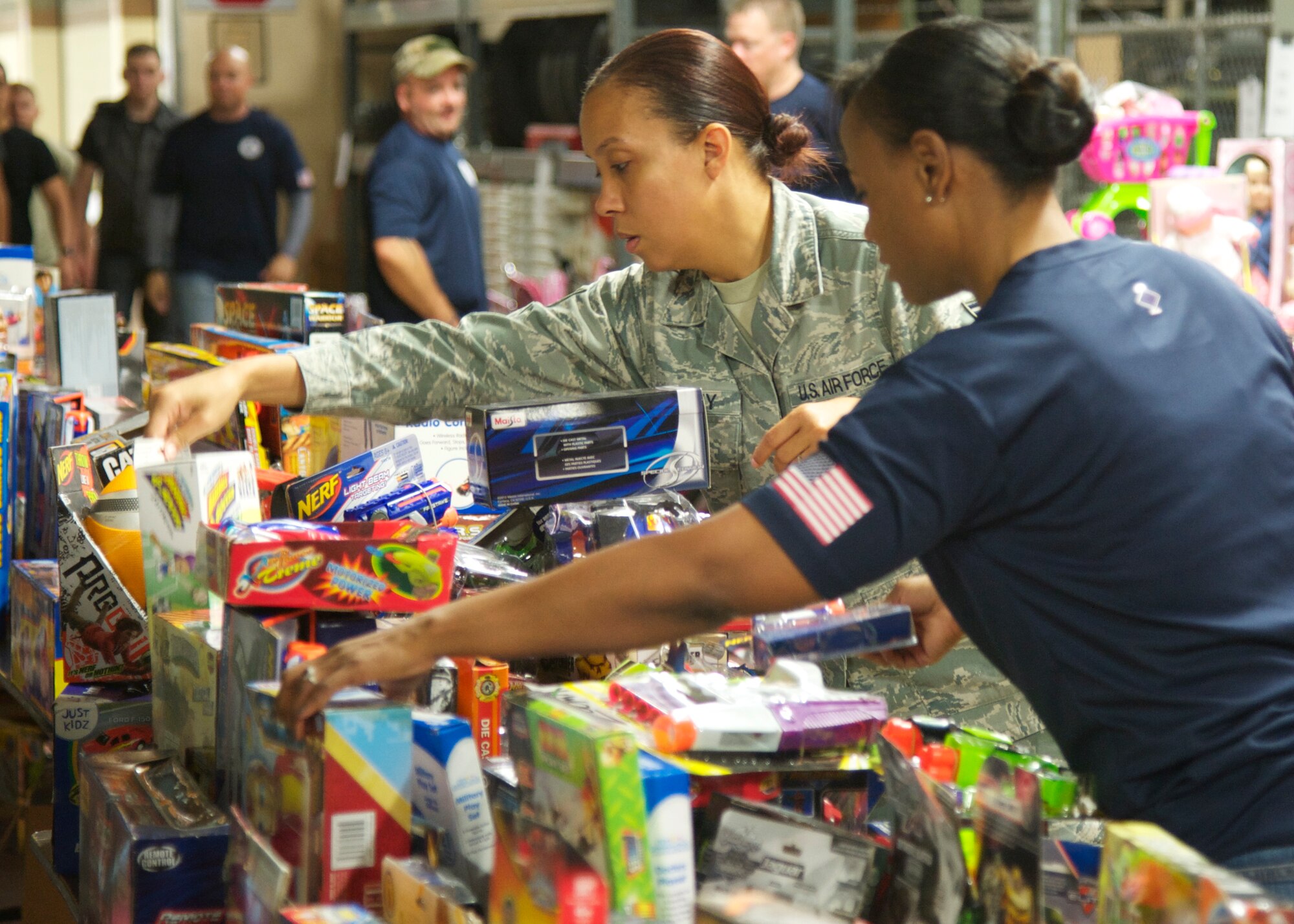 Master Sgt. Yvette Hughes-Mayo, of the 96th Maintenance Squadron, assists Staff Sgt. Ashawntee Worley, of the 96th Force Support Squadron, pick out a toy at the 10th annual toy drive held at Eglin Air Force Base, Fla., Nov. 22. More than 11,000 toys were donated to the Airman’s Attic, helping more than 300 families in the Eglin community. (U.S. Air Force photo/Sara Vidoni)
