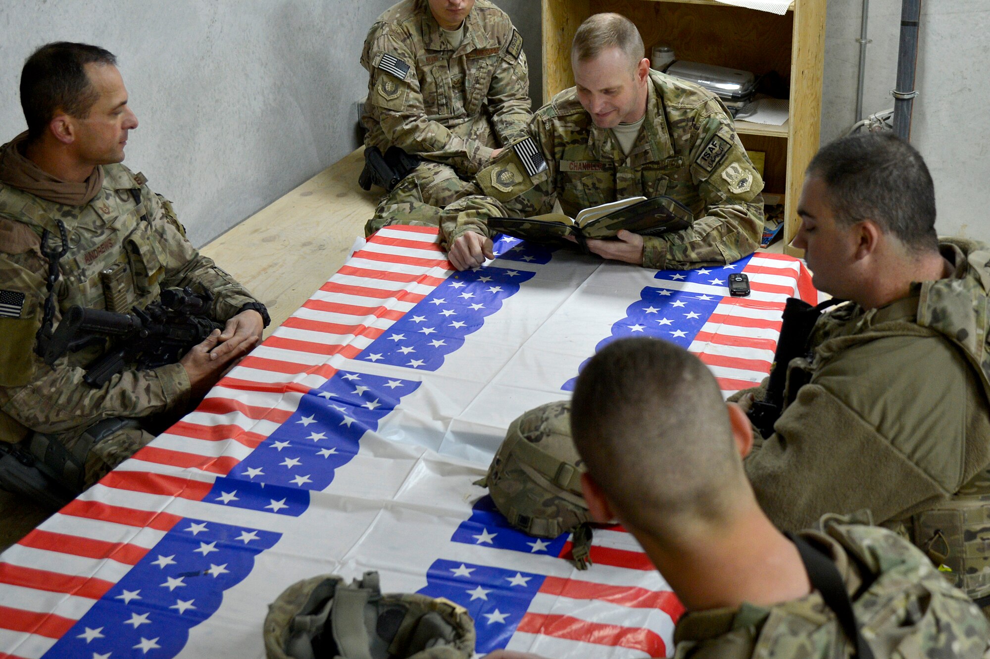 U.S. Air Force Chaplain (Capt.) Robert Chandler, 455th Air Expeditionary Wing, reads a scripture to members of the 455th Expeditionary Base Defense Squadron at Bagram Airfield, Afghanistan, Nov. 24, 2013. Chandler visited with the Airmen during guard mount. Chandler and Rivas are a religious support team assigned to the 455th EBDS. Chandler is deployed from Offutt Air Force Base, Neb. and hails from Greenville, S.C. (U.S. Air Force photo by Senior Airman Kayla Newman/Released)