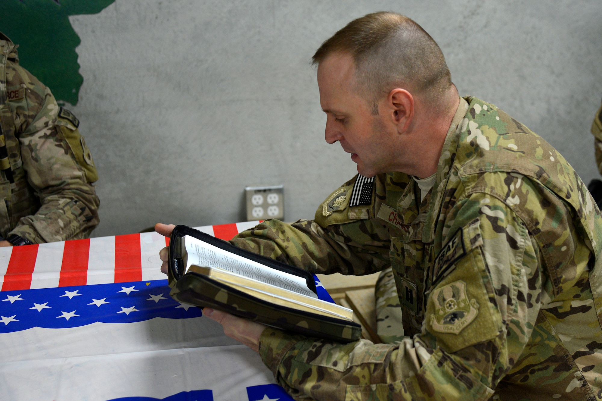 U.S. Air Force Chaplain (Capt.) Robert Chandler, 455th Air Expeditionary Wing, reads a scripture to members of the 455th Expeditionary Base Defense Squadron at Bagram Airfield, Afghanistan, Nov. 24, 2013. Chandler visited with the Airmen during guard mount. Chandler and Rivas are a religious support team assigned to the 455th EBDS. Chandler is deployed from Offutt Air Force Base, Neb. and hails from Greenville, S.C. (U.S. Air Force photo by Senior Airman Kayla Newman/Released)