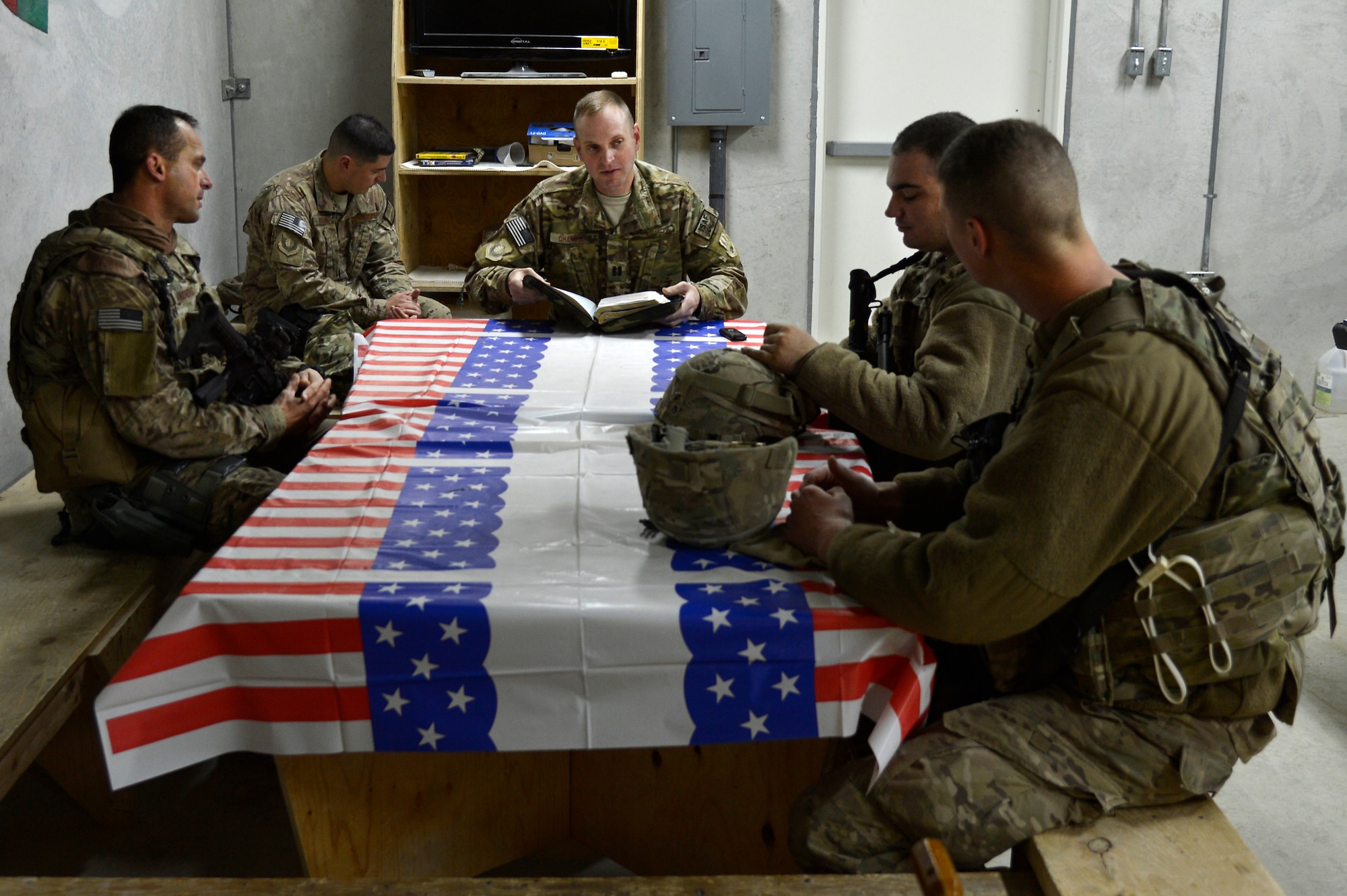 U.S. Air Force Chaplain (Capt.) Robert Chandler, 455th Air Expeditionary Wing, reads a scripture to members of the 455th Expeditionary Base Defense Squadron at Bagram Airfield, Afghanistan, Nov. 24, 2013. Chandler visited with the Airmen during guard mount. Chandler and Rivas are a religious support team assigned to the 455th EBDS. Chandler is deployed from Offutt Air Force Base, Neb. and hails from Greenville, S.C. (U.S. Air Force photo by Senior Airman Kayla Newman/Released)