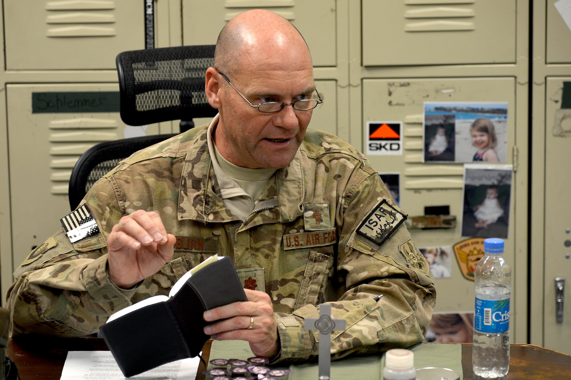 U.S. Air Force Chaplain (Maj.) Gary Coburn, 455th Air Expeditionary wing, reads a scripture for the 83rd Expeditionary Rescue Squadron at Bagram Airfield, Afghanistan, Nov. 24, 2013. Coburn held a small service for Airmen assigned to the 83rd ERQS in their briefing room. Coburn is deployed from Buckley Air Force Base, Colo. (U.S. Air Force photo by Senior Airman Kayla Newman/Released)