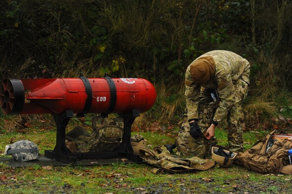 SPANGDAHLEM AIR BASE, Germany--A member of the 52nd Civil Engineer Squadron Explosive Ordnance Disposal flight unzips his ruck sack after marching to the EOD range for a pumpkin demo Nov. 6, 2013. To start off the pumpkin demo, EOD members hiked out to the range. (U.S. Air Force photo by Senior Airman Rusty Frank/Released)