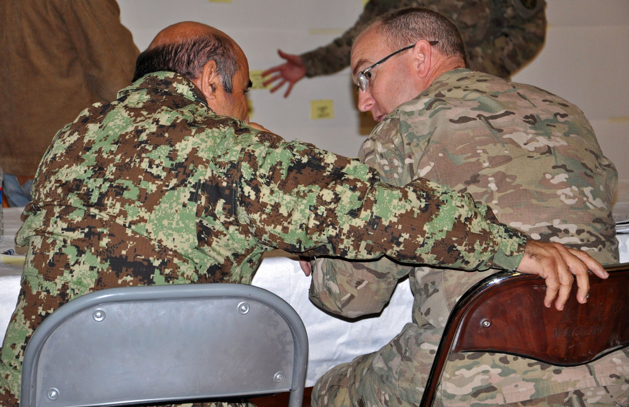 U.S. Air Force Col. Kendall Peters, NATO Air Training Command-Afghanistan director of personnel and training, discusses the future of maintenance training with the Kabul Air Wing Group Training Commander Nov. 13, 2013 at Kabul International Airport, Afghanistan. Advisors with NATC-A, along with their AAF counterparts, held an education and maintenance training summit Nov. 9 to 13, 2013. The summit focused on evaluating the current method of training the AAF maintenance force and identifying ways to restructure the training in order to more efficiently educate maintainers. (U.S. Air Force photo/Capt. Anastasia Wasem)