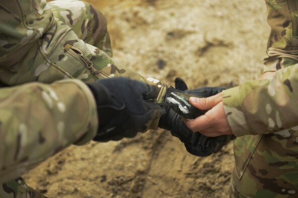 SPANGDAHLEM AIR BASE, Germany-- Members from the 52nd Civil Engineer Squadron Explosive Ordnance Disposal flight make holes in C-4 prior to exploding a pumpkin during a training session Nov. 11, 2013. The holes are made in the C-4 to allow the EOD technicians to insert the blasting caps for detonation. (U.S. Air Force photo by Senior Airman Rusty Frank/Released)