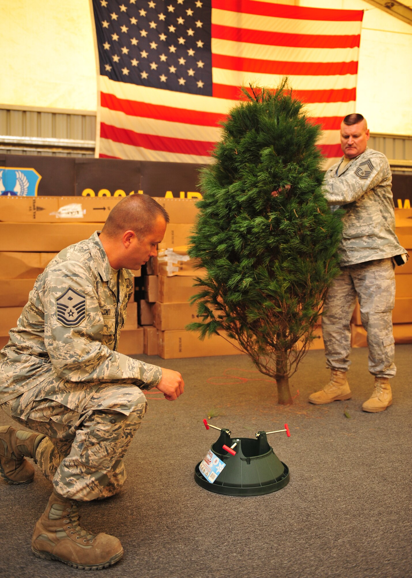 Chief Master Sgt. Gary Meacham, 380th Expeditionary Aircraft Maintenance Squadron, and Master Sgt. Thomas Smith, 380th EAMXS first sergeant, assemble a Christmas tree from Trees for Troops at an undisclosed location in Southwest Asia, Nov. 24, 2013. More than 122,000 free, farm grown Christmas trees have been provided to members every branch of the military at more than 60 bases in 17 countries since 2005. (U.S. Air Force photo by Staff Sgt. Michael Means/Released)