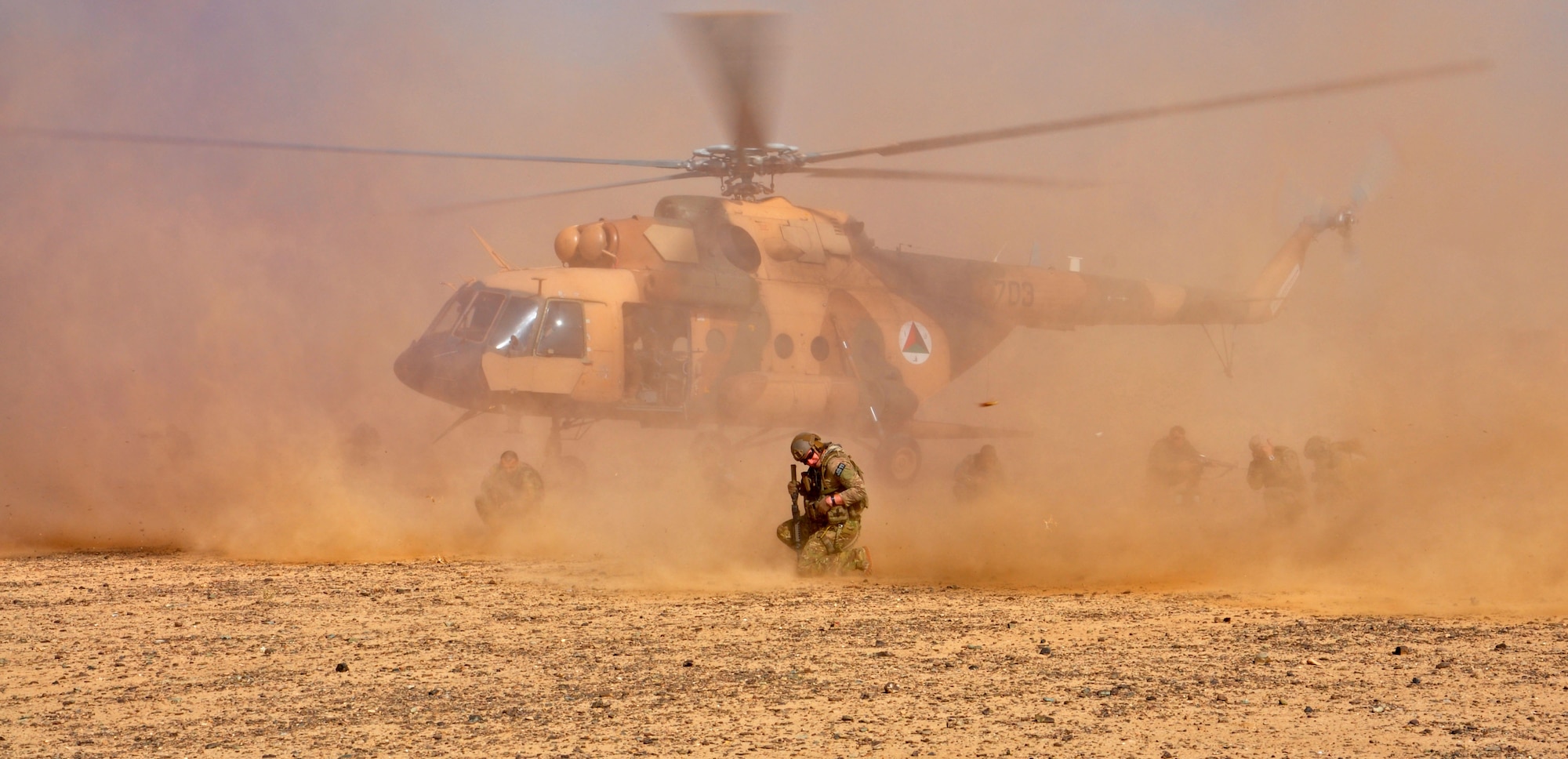 Advisors with NATO Air Training Command-Afghanistan and Afghan Air Force members shield themselves as a Mi-17 helicopter lands as part of an air assault training exercise Nov. 10, 2013 near Kandahar Airfield, Afghanistan. Members of the Kandahar Air Wing Security Forces Kandak conducted fly away training with NATC-A advisors from the 443rd and 441st Air Expeditionary Advisory Squadrons. The 18-person class was taught the basics of air assault, including infiltration and exfiltration, unloading and loading from an aircraft and how to secure an aircraft. (U.S. Air Force photo/Capt. Anastasia Wasem)