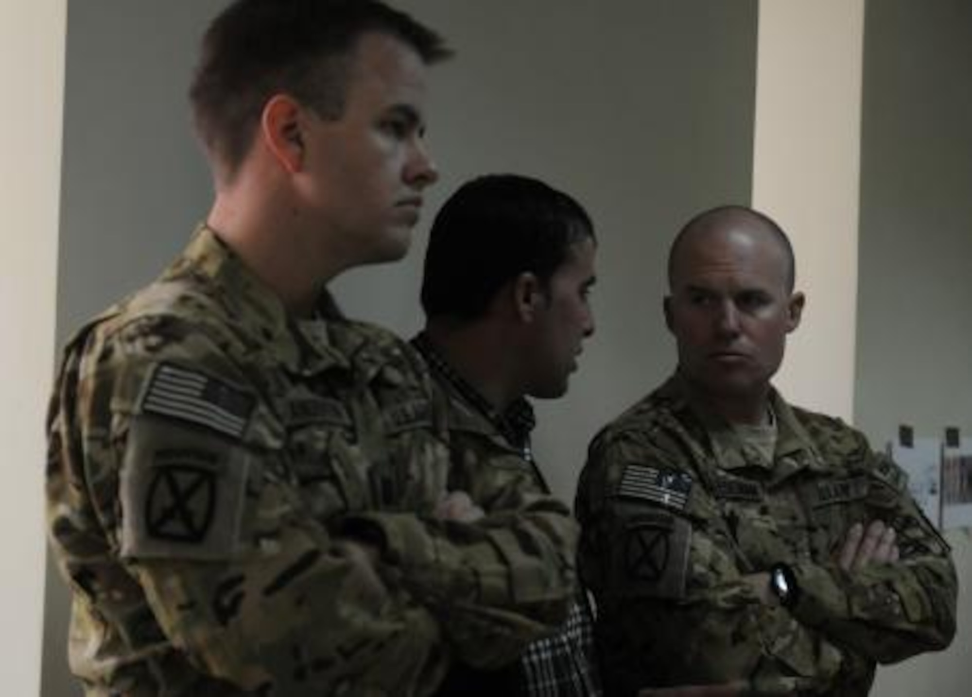 U.S. Army Capt. Brandt Anderson, the Task Force Falcon team leader for the Kabul Air Wing Partnership and a CH-47 Chinook helicopter pilot; and U.S. Army Chief Warrant Officer 2 Kyle Cheeseman, a UH-60 Black Hawk helicopter instructor pilot, both from the U.S. Army’s 10th Combat Aviation Brigade, listen to a translator during an after-action review Nov. 5, 2013. The AAR was led by an Afghan Air Assault Planning Certification Course instructor. The U.S. advisors have symbolically moved from being seated at the table with the class, to the back of the room, as their role becomes assessing the Afghan instructors training Afghan flight crews. (Photo by Staff Sgt. Todd Pouliot, 10th Combat Aviation Brigade, 10th Mountain Division Public Affairs)