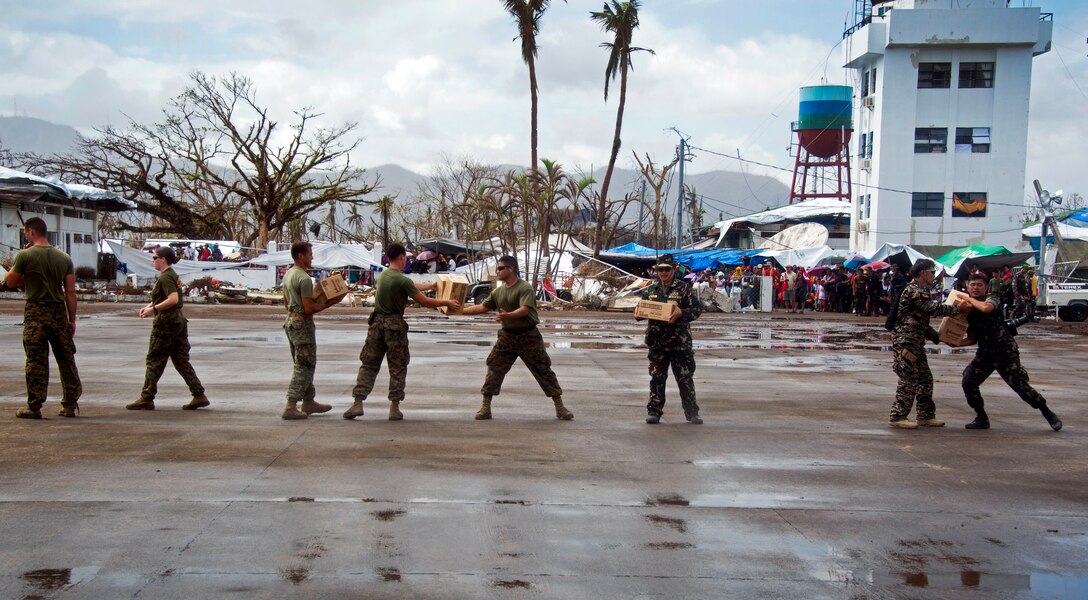 U.S. and Philippine marines unload relief supplies delivered by the USS Freedom during Operation Damayan in Tacloban, Philippines, Nov. 24, 2013. U.S. Marines and sailors, assigned to Joint Task Force 505, are conducting search and rescue, supply drops and personnel airlifts in support of Operation Damayan.