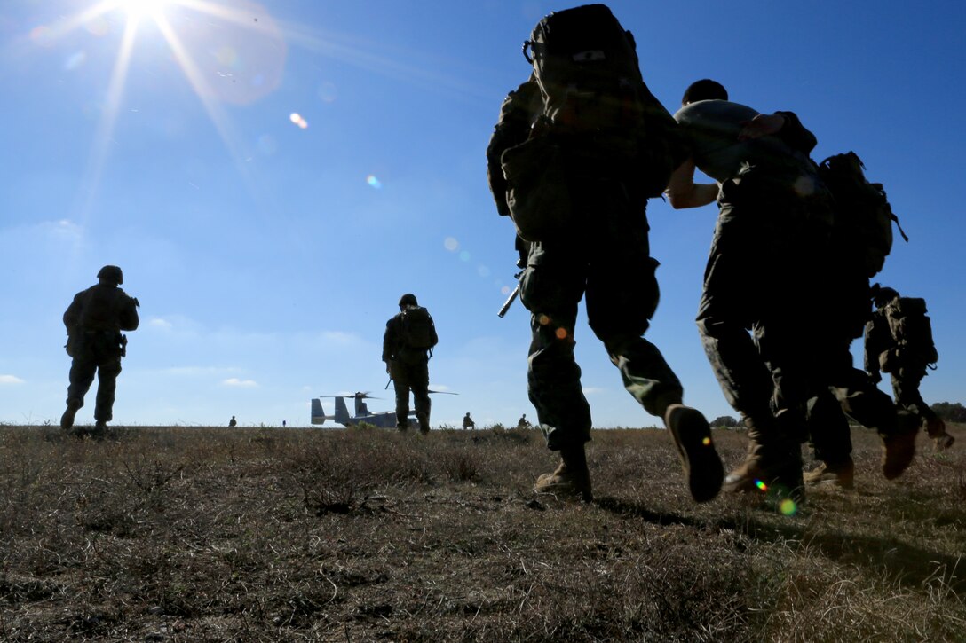 Marines and Sailors with Special Purpose Marine Air-Ground Task Force Crisis Response (SP-MAGTF Crisis Response) carry a simulated downed pilot toward an MV-22B Osprey during a tactical recovery of aircraft and personnel training exercise as part of Theater Marine Integration Training (TMIT) at Naval Station Rota, Spain, Nov. 19, 2013. TMIT was a multi-unit exercise intended to bring together diverse Marine Corps assets to accomplish a unified goal. The units included Black Sea Rotational Force 14, SPMAGTF Crisis Response, Fleet Antiterrorism Support Team, and Special Purpose Marine Air-Ground Task Force Africa.