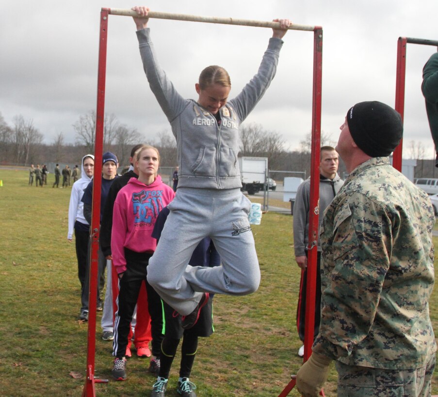 Guest Kala Thompson, from Ballard, W.Va., struggles to do another pull-up while being motivated by U.S. Marine Corps Staff Sgt. Sean Slaven, the administrative chief of Recruiting Station Charleston and a native of East Berlin, Pa., Nov. 23, 2013. Thompson was one of over 100 individuals who competed in RS Charleston’s statewide pool meet, which was held to increase camaraderie amongst the various recruiting sub-stations and have the poolees learn a little about recruit training life. (U.S. Marine Corps photo by Sgt. Tyler J. Hlavac/Released)