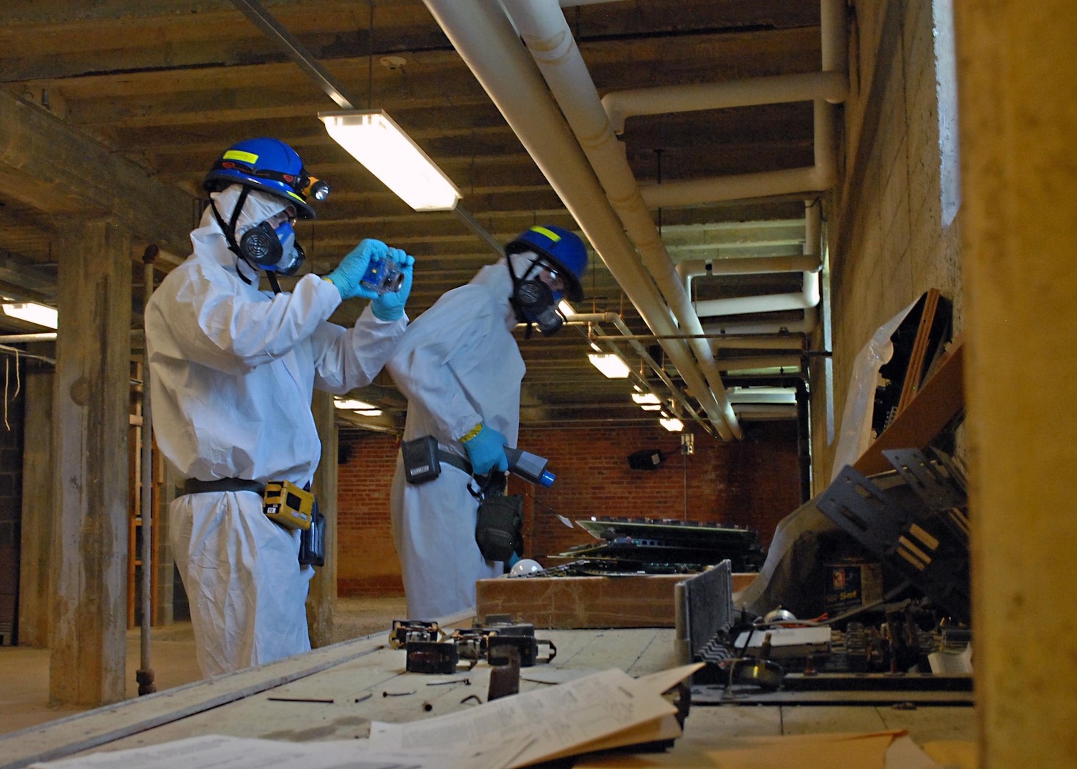 Kansas Army and Air National Guard members assigned to the 73rd Civil Support Team - Weapons of Mass Destruction - take pictures, and use chemical, biological, radiological and nuclear (CBRN) equipment to detect possible hazardous contaminants in the basement of a school during a Vibrant Response 13 field training exercise at the Muscatatuck Urban Training Center, Ind, Aug. 6, 2012. The chemical specialists were responsible for documenting and relaying information of contaminated areas to other Joint Task Force Civil Support units during the training venue.