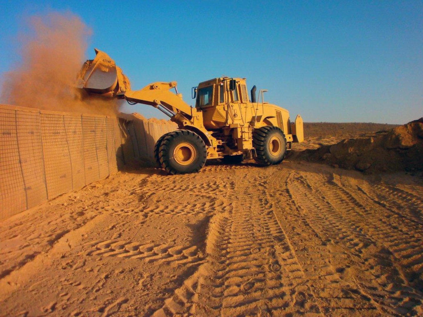 South Dakota Army National Guard Spc. Kyle Griffith of the 842nd Horizontal Construction Company fills barricades at Combat Outpost Giro. Giro was so isolated from the rest of the project sites it had to be resupplied by helicopter.