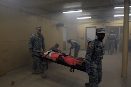 Medics from the Alabama Army National Guard's 129th Area Support Medical Company, strap mannequins and role-players to litters and evacuate them from a building at Muscatatuck Urban Training Complex, Ind. "It's always important for medics to practice mass causality incidents because those are usually the most stressful and resource intensive," said Sgt. 1st Class Richard Pike, a platoon sergeant with the 129th ASMC. The Soldiers have been honing their skills while participating in Vibrant Response 13, a major field training exercise conducted by U.S. Northern Command and U.S. Army North.