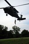 Army Pvt. Cory M. Perry, an infantryman with the Kentucky Army National Guard's Company A, 1st Battalion 149th Infantry Regiment, fast ropes from a UH-60 Black Hawk helicopter during a fast rope insertion training exercise at the Harold L. Disney Training Center in Artemus, Ky.