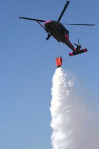 Aircrews from the 129th Rescue Wing use an HH-60 Pave Hawk helicopter to drop water on a wildfire in 2008. Aircrews from the unit are currently working with state and local officials to suppress the Jawbone Complex wildfire in Kern County, Calif.