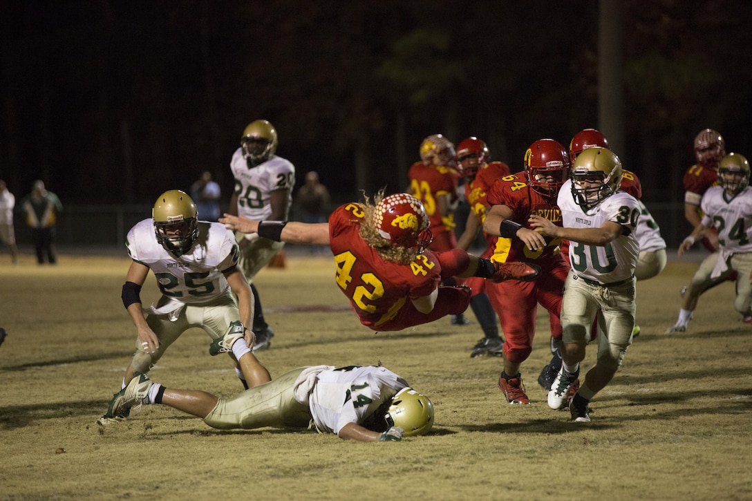 Stephen DiCenso Jr., Lejeune Bulldogs’ running back, leaps for yardage after being hit by a North Duplin Rebels player at the second round of the North Carolina High School Athletic Association playoffs aboard Marine Corps Base Camp Lejeune, Nov. 22.