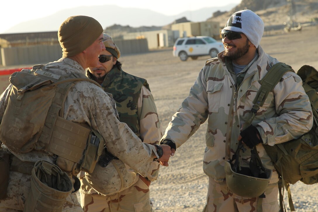A team leader with Company K, 3rd Battalion, 5th Marine Regiment, greets translators before a counter insurgency exercise at the Combat Center’s Range 215, Nov. 18th, 2013.