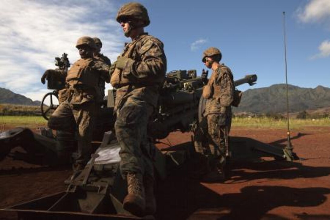 Marines with Bravo Battery, 1st Battalion, 12th Marine Regiment, wait for the call to fire an M777 howitzer during a dual fire exercise at Schofield Barracks, Hawaii, Nov. 13, 2013. The dual-fire exercise included shooting two M327 Towed-Rifled Mortar Systems alongside four M777s during the two-day training exercise.
