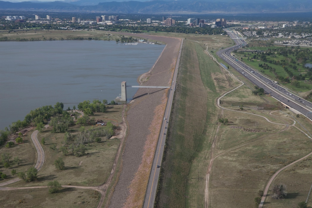 Cherry Creek Dam, completed around 1950, was built and is operated by the U.S. Army Corps of Engineers for the primary purpose of flood risk mitigation. Cherry Creek Dam is an earth-fill embankment dam with an outlet structure for operational water releases. The embankment is 14,300 feet long with a maximum height of 141 feet. The dam’s outlet structure is a triple barrel concrete conduit system through which water discharges into the Cherry Creek channel located a short distance downstream.