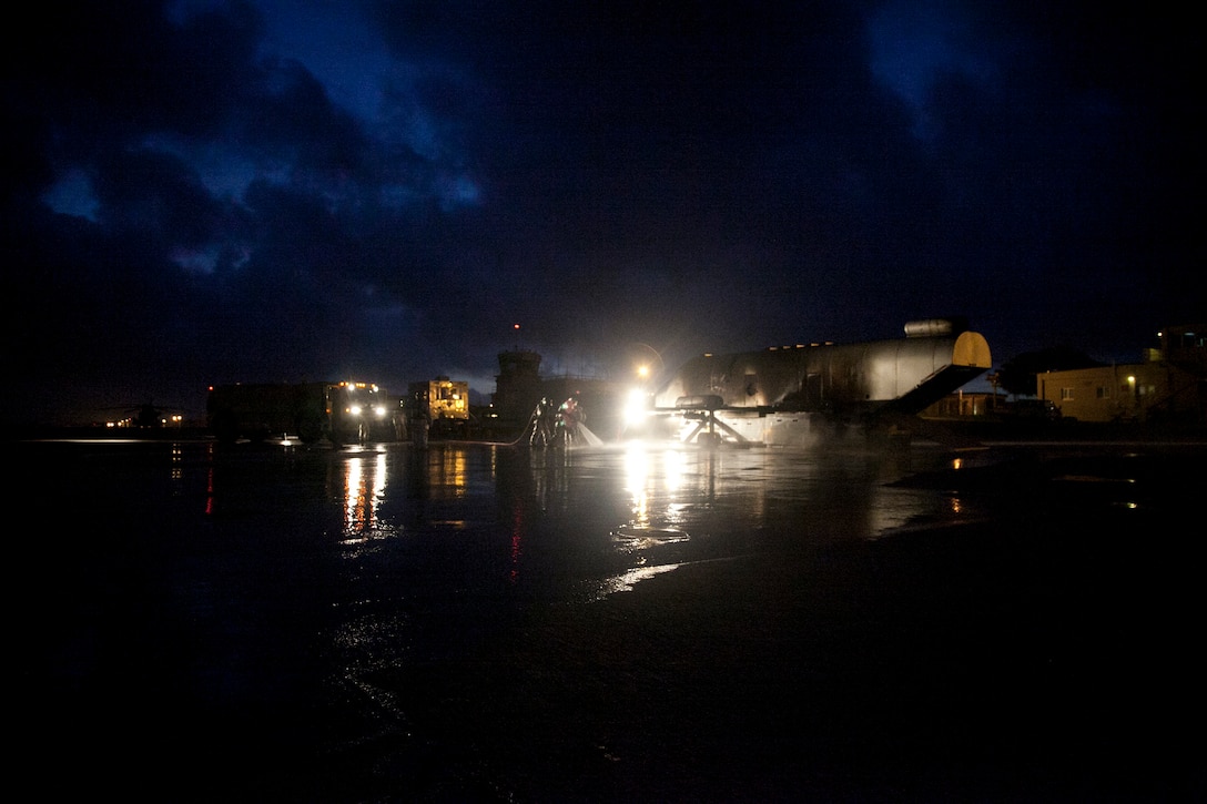 Marines extinguish a fire on a mobile aircraft fire training device Sept. 18 at Marine Corps Air Station Futenma. During the training, a senior ARFF specialist stands near the Marines extinguishing the fire to ensure they practice the proper techniques. The Marines are ARFF specialists with Headquarters and Headquarters Squadron.