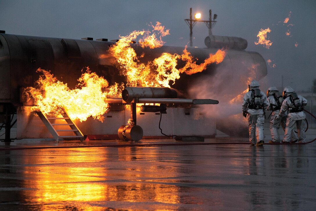 Marines extinguish a fire on a mobile aircraft fire training device Sept. 18 at Marine Corps Air Station Futenma. During the training, a senior ARFF specialist stands near the Marines extinguishing the fire to ensure they practice the proper techniques. The Marines are ARFF specialists with Headquarters and Headquarters Squadron.