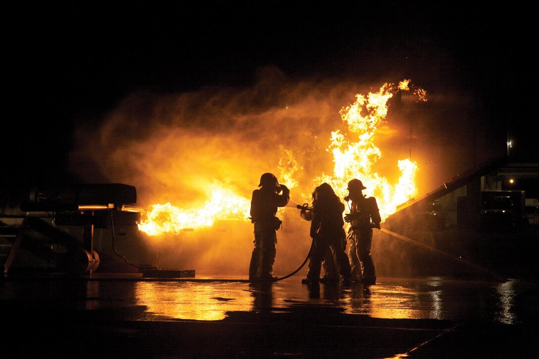 Marines extinguish a fire on a mobile aircraft fire training device Sept. 18 at Marine Corps Air Station Futenma. The device is self-contained, uses propane, and can only be extinguished by stopping the fuel source. The Marines are aircraft rescue and firefighting specialist with Headquarts and Headdquarters Squadron, MCAS Futenma, Marine Corps Installations Pacific.