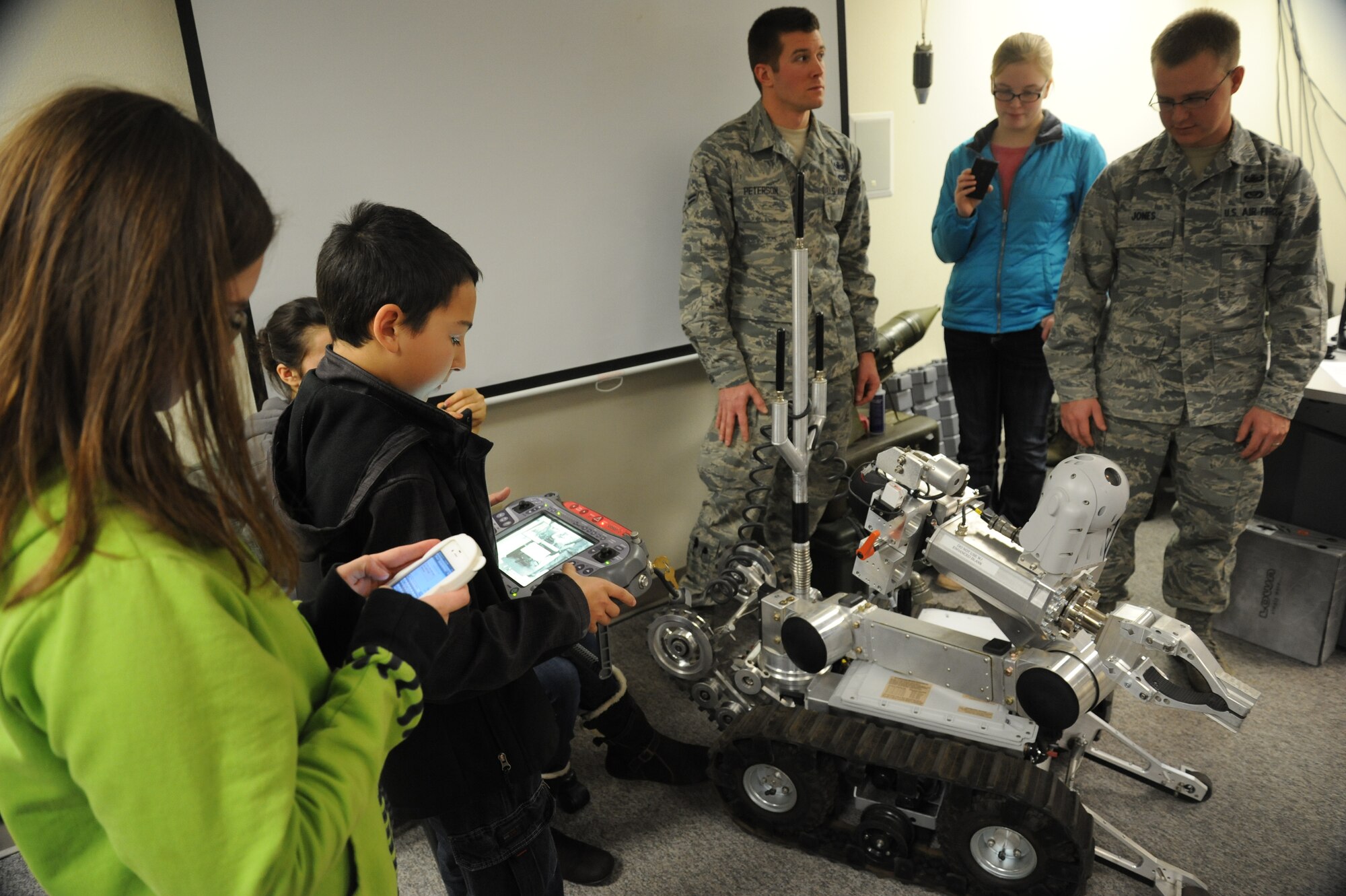 Airman 1st Class Luke Peterson and Senior Airman Christopher Jones, 92nd Civil Engineer Squadron explosive ordnance disposal technicians, give West Valley High School students an opportunity to operate the F6A explosive ordnance robot at Fairchild Air Force Base, Wash., Nov. 22, 2013.  The students toured the base to learn more about the greater community.  (U.S. Air Force photo by Airman 1st Class Sam Fogleman/Released)