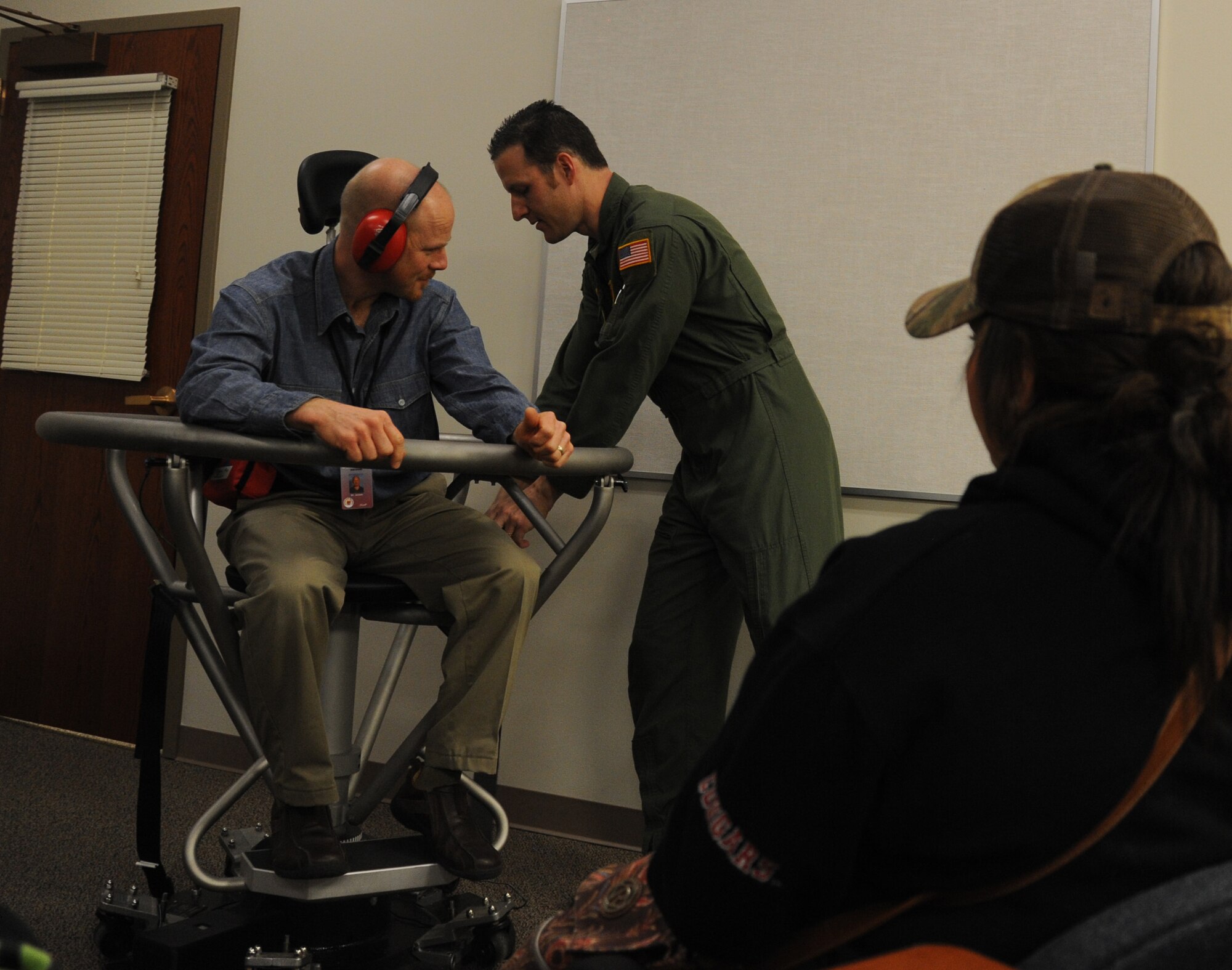 Lt. Col. Matthew Albright, 92nd Aerospace Medicine Squadron aerospace physiological training flight commander, prepares a teacher from Spokane’s West Valley High School for the Barany chair at Fairchild Air Force Base, Wash., Nov. 22, 2013.  Spinning on the Barany chair helps Airmen understand spatial disorientation and learn to trust their instruments.  (U.S. Air Force photo by Airman 1st Class Sam Fogleman/Released)