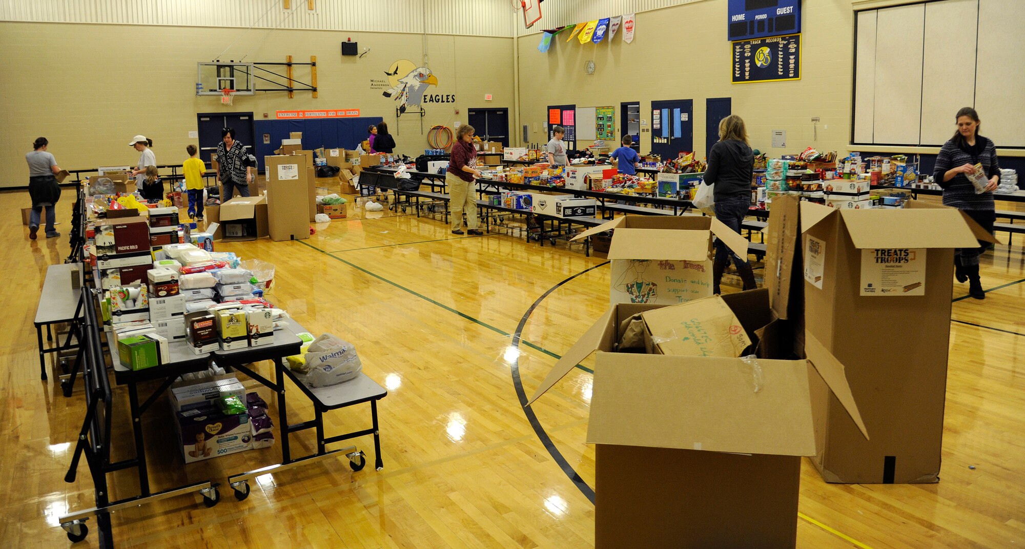 Donations are sorted inside the Michael Anderson Elementary School gymnasium at Fairchild Air Force Base, Wash., Nov. 26, 2013. The donations are donated for Treats 2 Troops, a program held by local news station KREM 2. Treats 2 Troops provides deployed Airmen care packages during the Holiday Season. (U.S. Air Force photo by Airman 1st Class Ryan Zeski/Released)