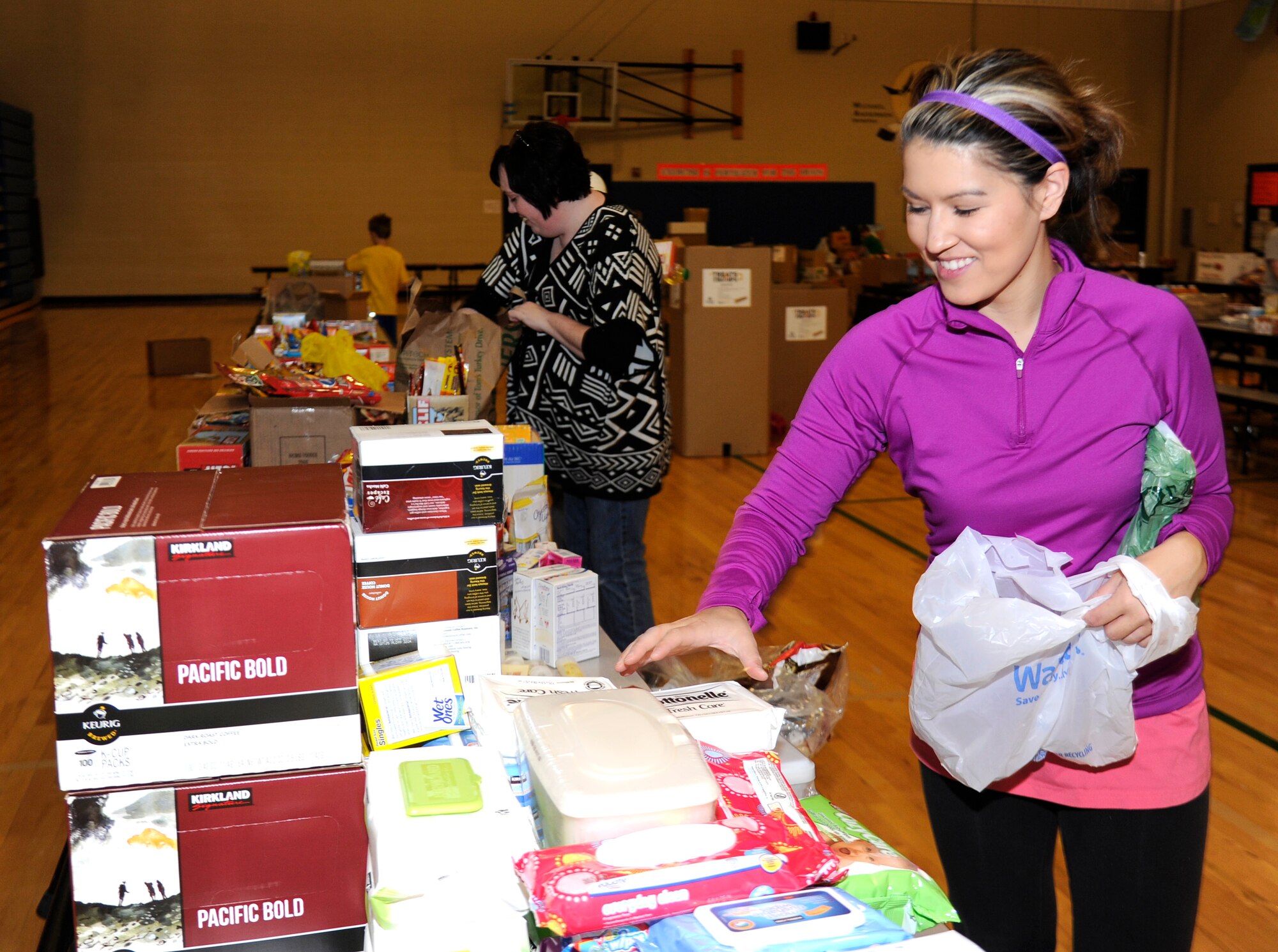Bailey Covieo, a Treats 2 Troops volunteer, sorts through goods at Fairchild Air Force Base, Wash., Nov. 26, 2013. The donations are donated for Treats 2 Troops, a program held by local news station KREM 2. Treats 2 Troops provides deployed Airmen care packages during the Holiday Season. (U.S. Air Force photo by Airman 1st Class Ryan Zeski/Released)