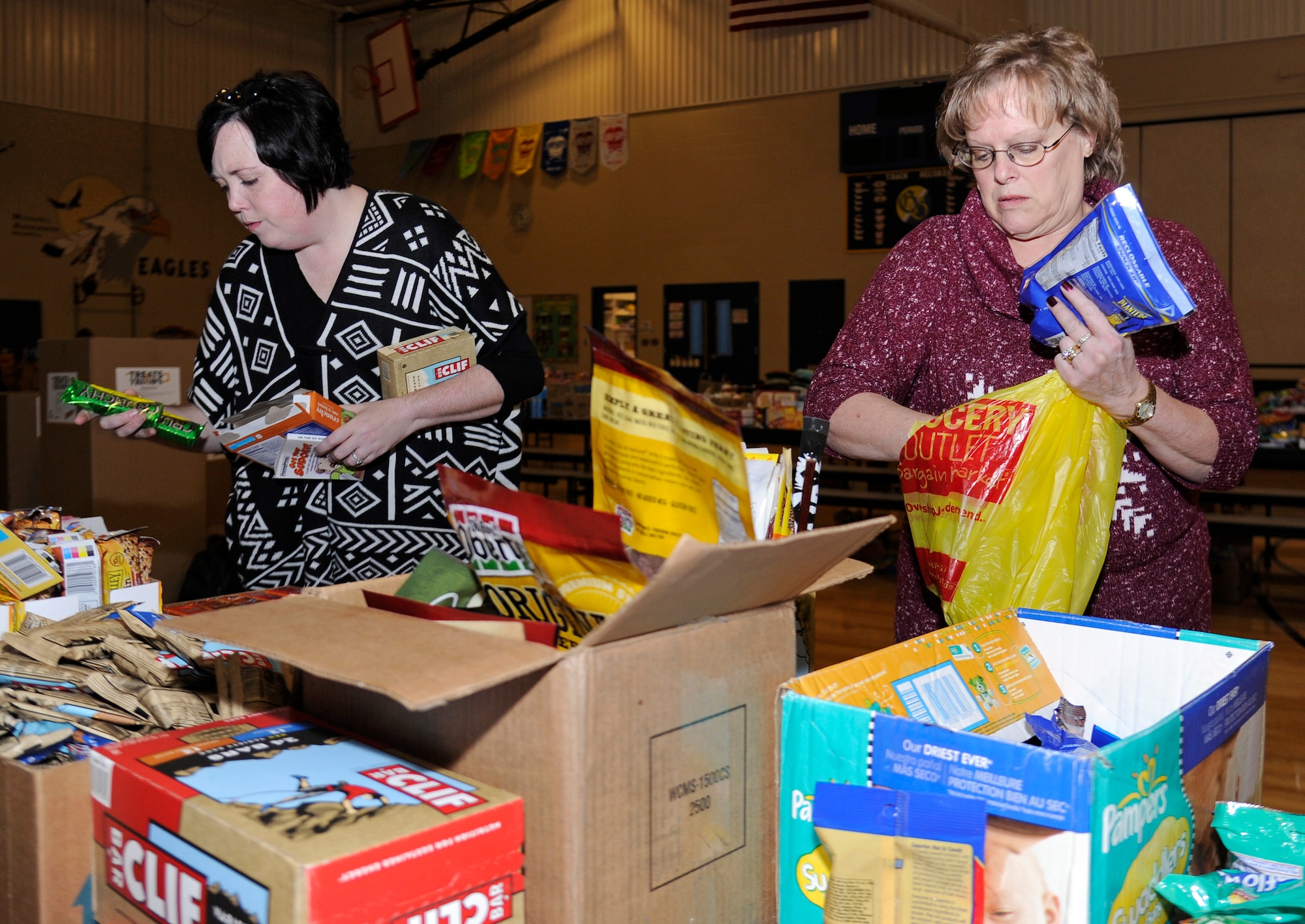 Brandi Ogren and Debbie Ristan, members of the spouses club, sort through goods donated to deployed Airmen at Fairchild Air Force Base, Wash., Nov. 26, 2013. The donations are donated for Treats 2 Troops, a program held by local news station KREM 2. Treats 2 Troops provides deployed Airmen care packages during the Holiday Season. (U.S. Air Force photo by Airman 1st Class Ryan Zeski/Released)