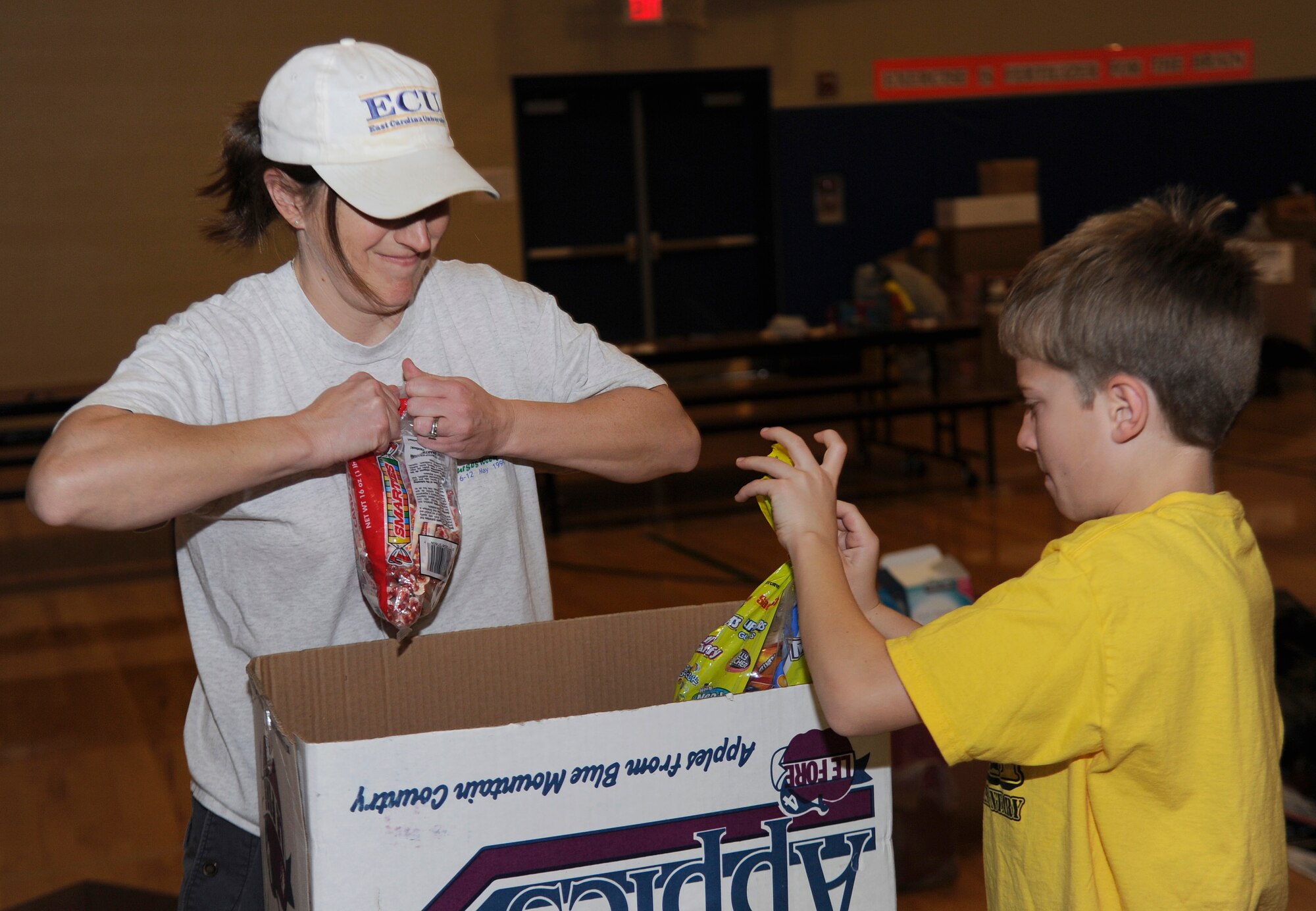 Christie Lennen and her son Colton, sort through donations inside the Michael Anderson Elementary School gymnasium at Fairchild Air Force Base, Wash., Nov. 26, 2013. The donations are donated for Treats 2 Troops, a program held by local news station KREM 2. Treats 2 Troops provides deployed Airmen care packages during the Holiday Season. (U.S. Air Force photo by Airman 1st Class Ryan Zeski/Released)