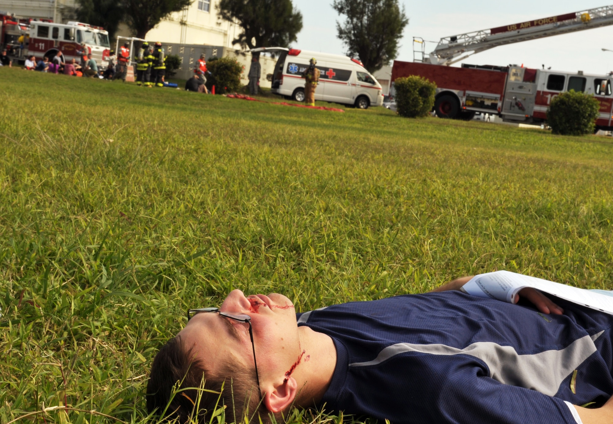 A simulated patient lies on the ground during an emergency management exercise at Marek Park on Kadena Air Base, Japan, Nov. 21, 2013. Approximately 20 18th Medical Group members participated in the exercise as simulated patients. (U.S. Air Force photo by Naoto Anazawa)