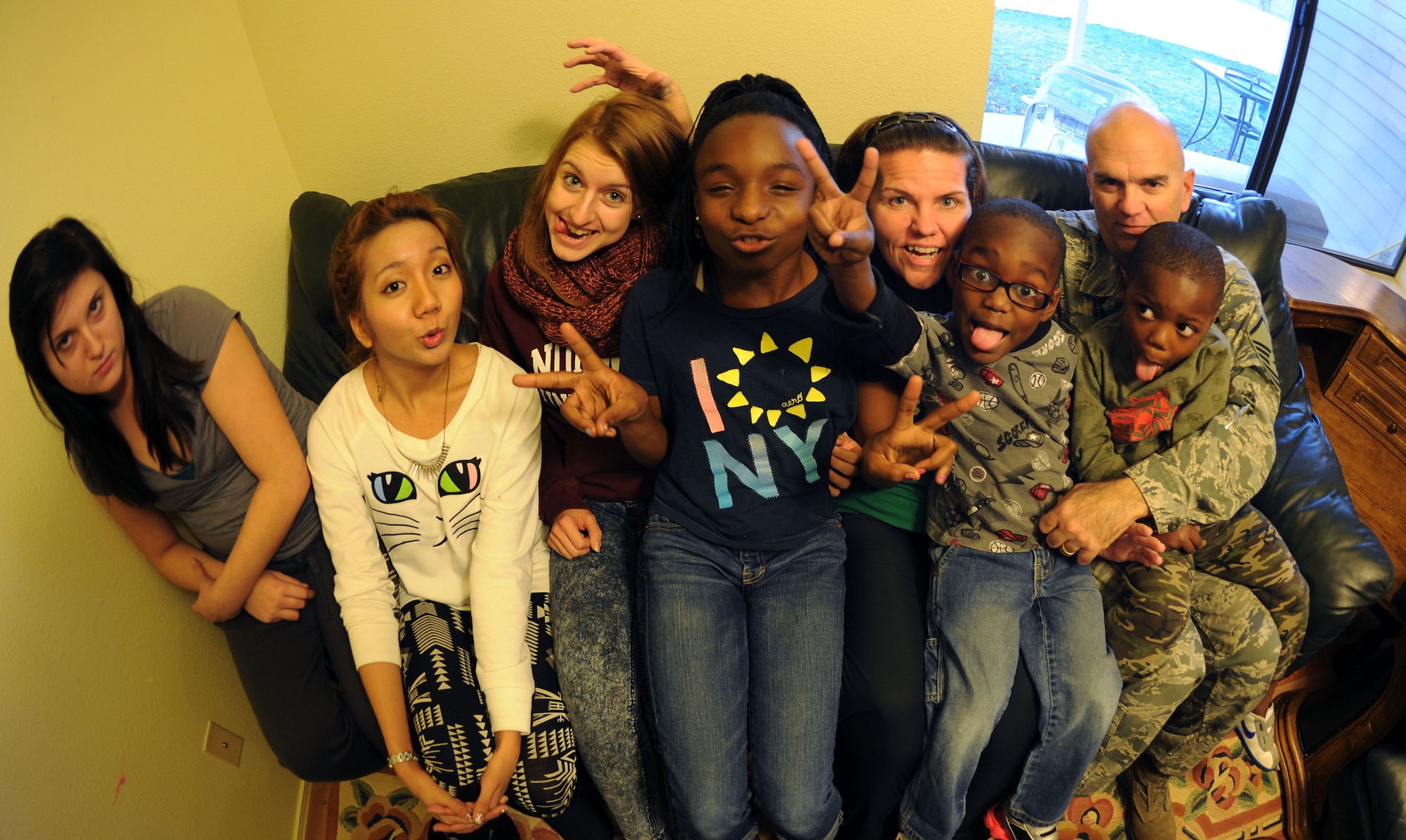 Master Sgt. John Massad makes funny faces with his family for a photo at Fairchild Air Force Base, Wash., Nov. 22, 2013. John and his wife, Dolly, have a total of seven children; five of which are adopted and two are foreign exchange students. (U.S. Air Force photo by Airman 1st Class Janelle Patiño/Released)
